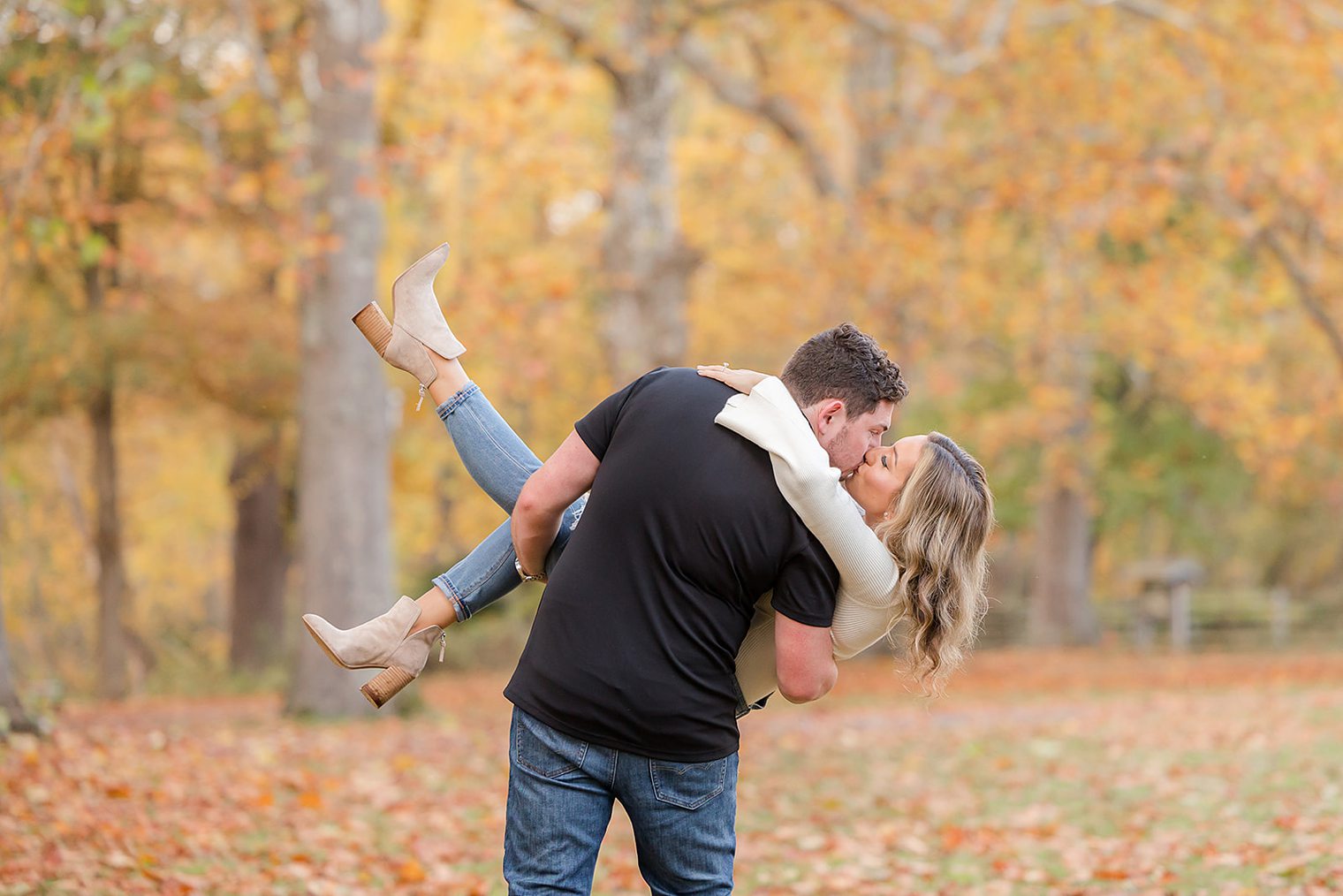 future husband holding up to his bride while they share a kiss