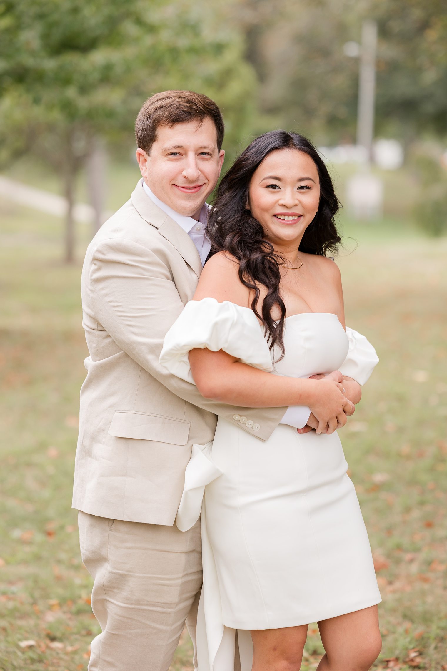 fiancé hugging his bride form behind 