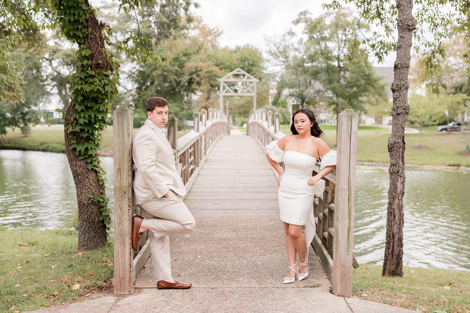 bride and her fiancé posing in front of the bridge at spring lake 