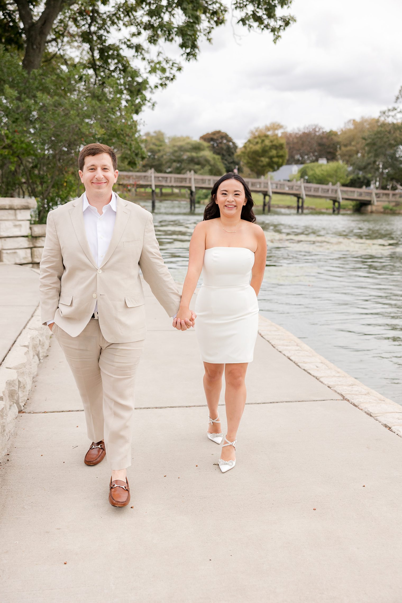 bride and fiancé holding hands while they walk 