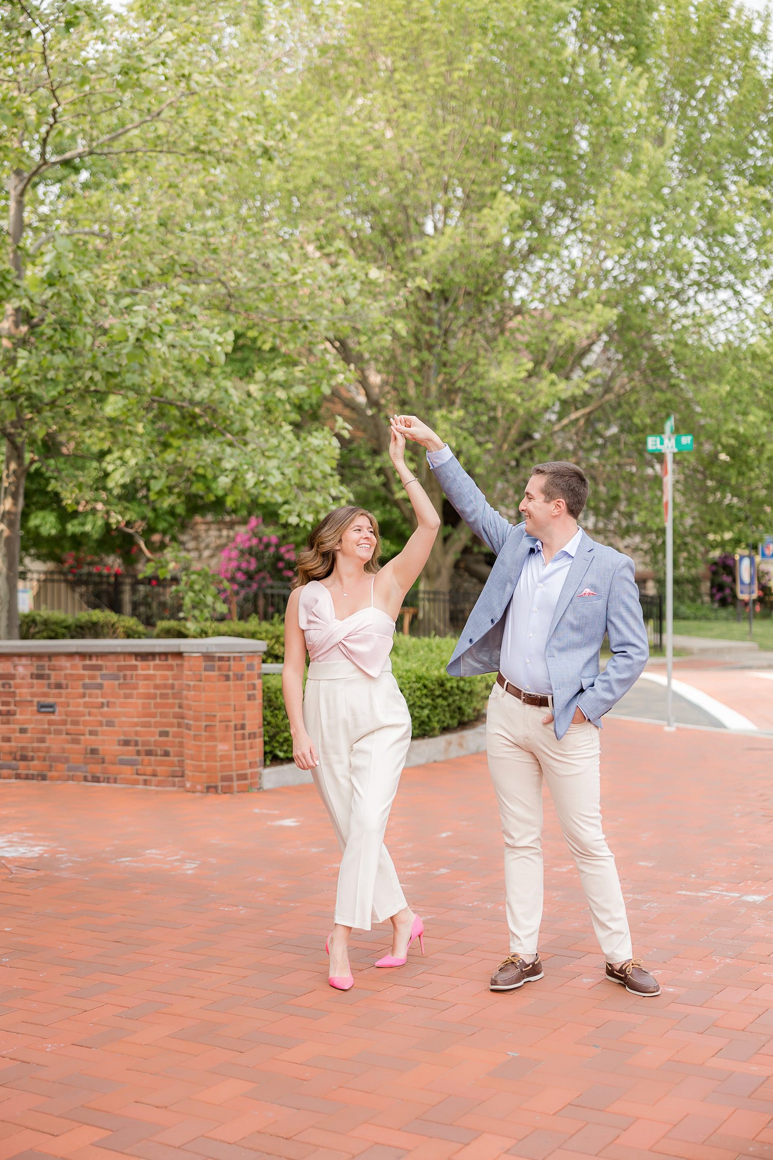 fiancé holding up his bride hand, while she's spinning 