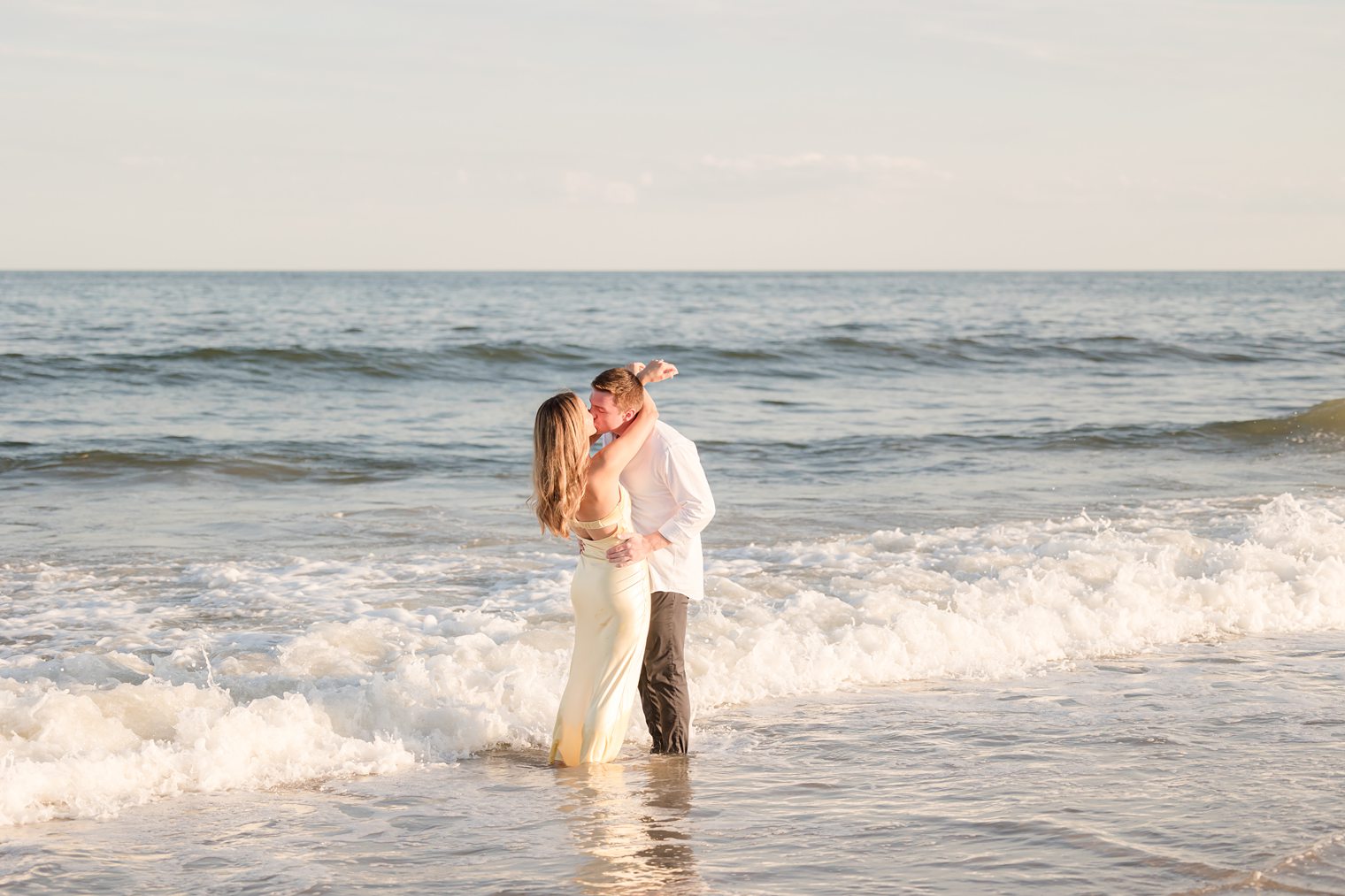 future husband and wife sharing a kiss in the beach