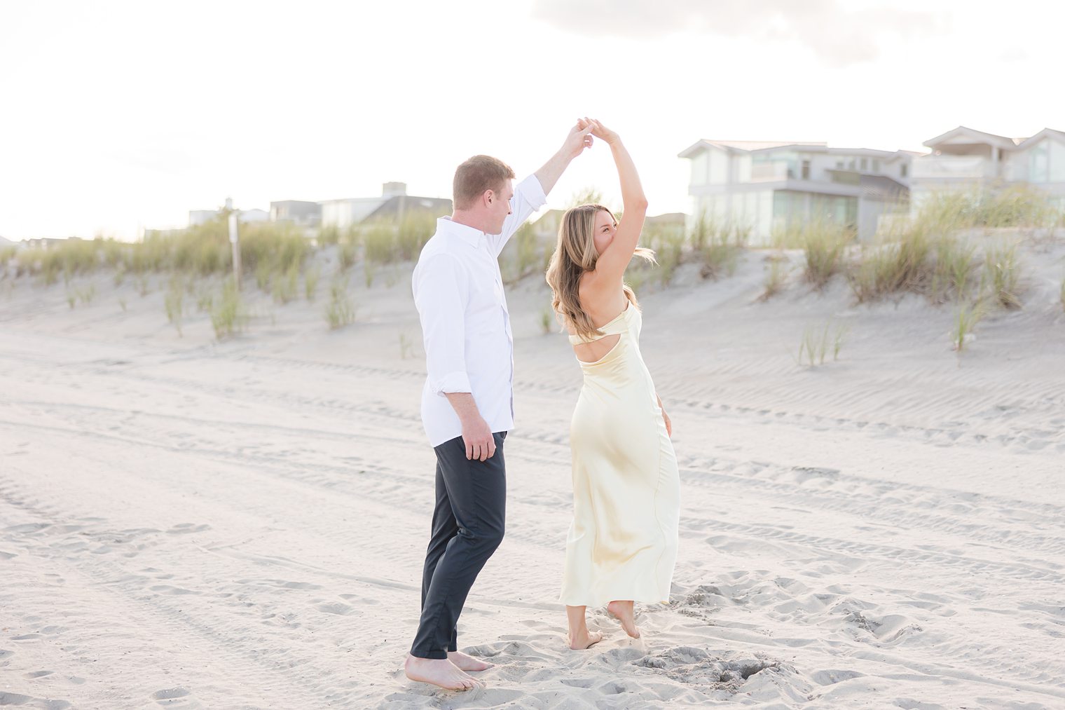 fiancé making his bride dance in the beach 
