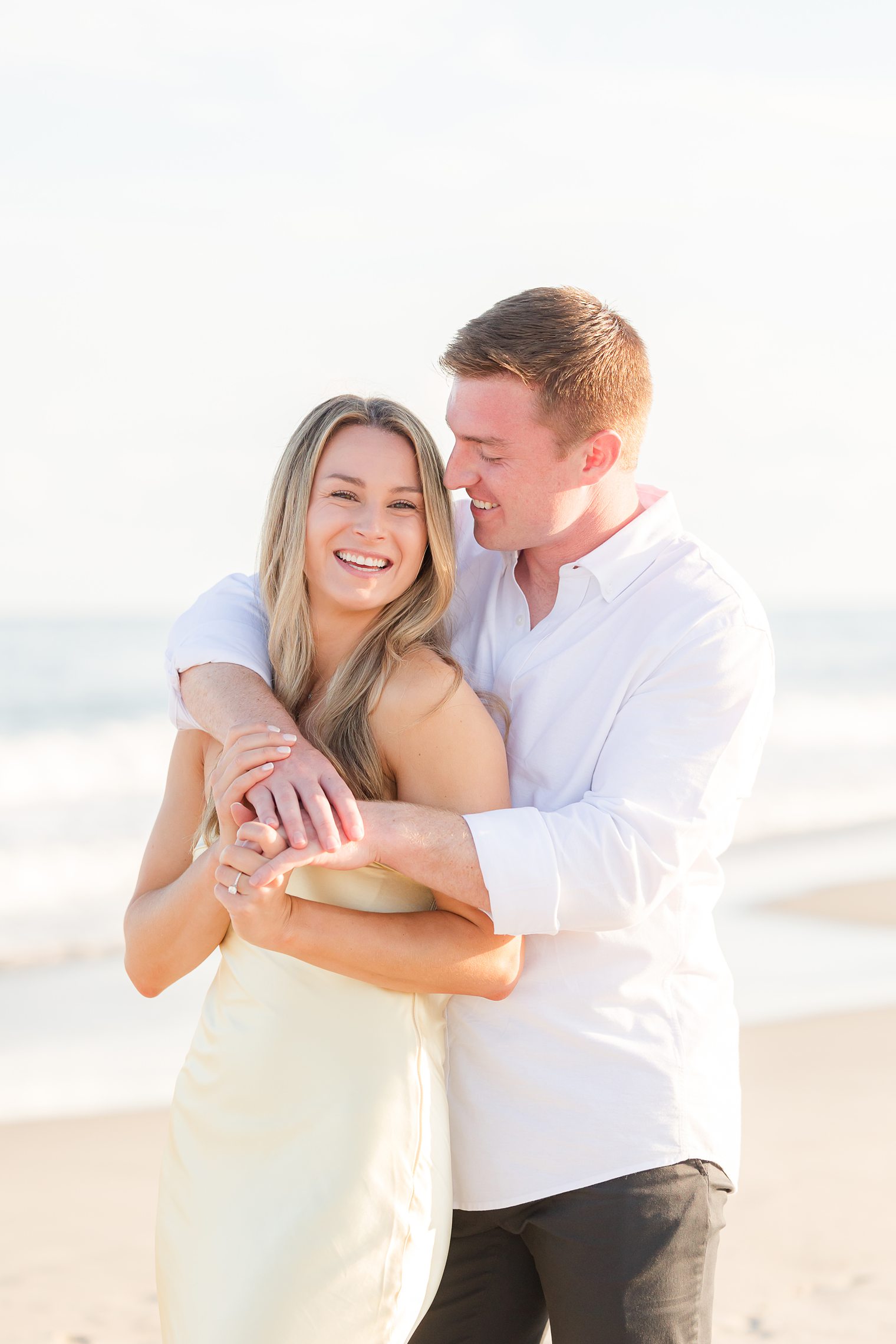 future husband putting his arms around his bride back