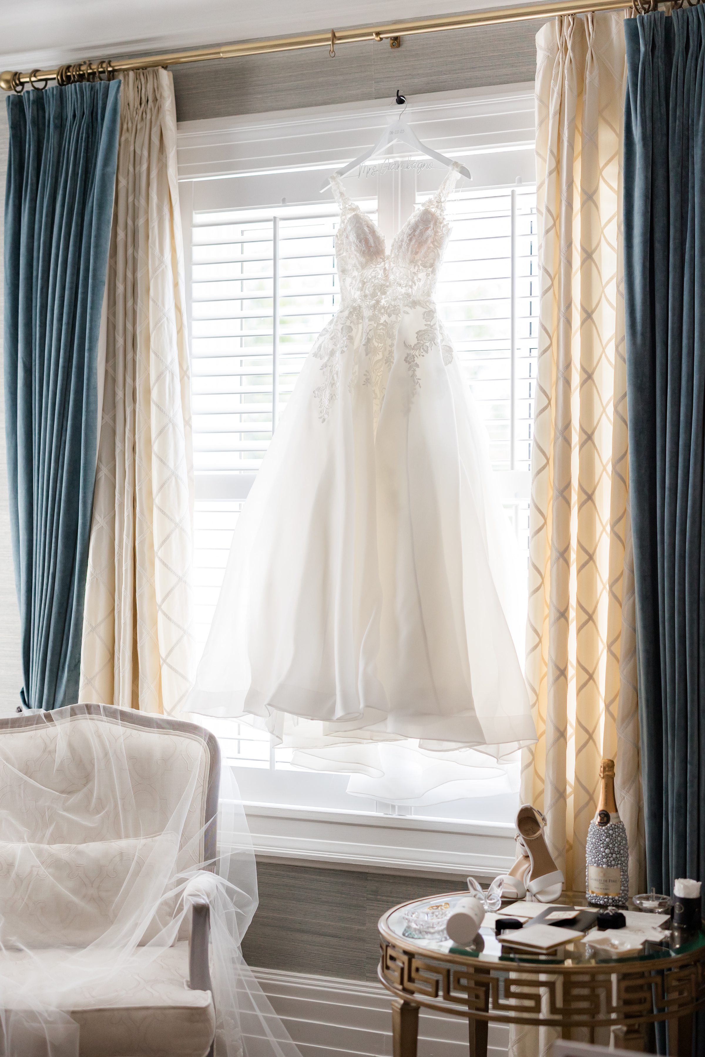 lace wedding dress hanging in a window at Shadowbrook in Shrewsbury, NJ 