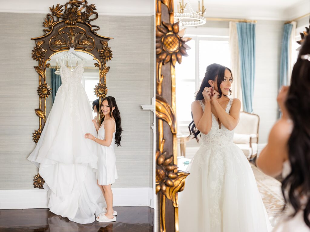 Bride is holding the wedding gown hanging on the mirror and wearing it together with earrings while looking at the mirror
