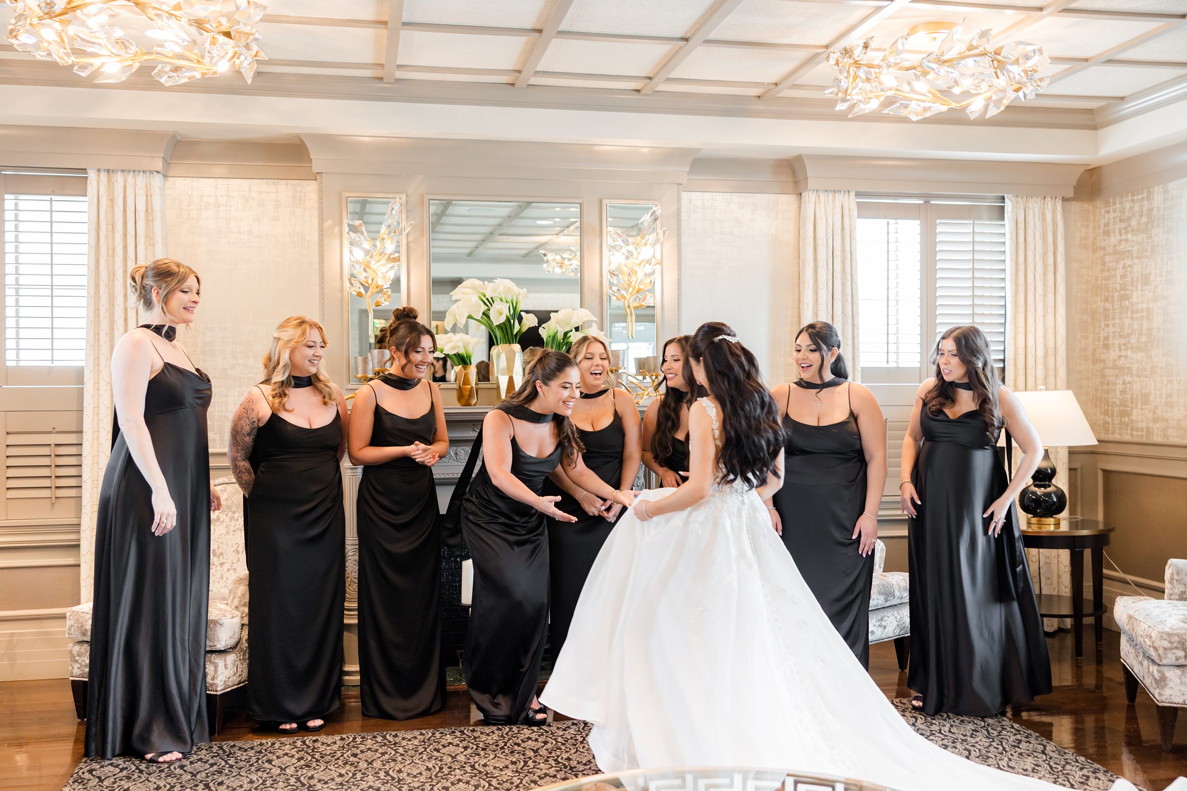Bridesmaids are checking out the lace wedding dress the bride is wearing