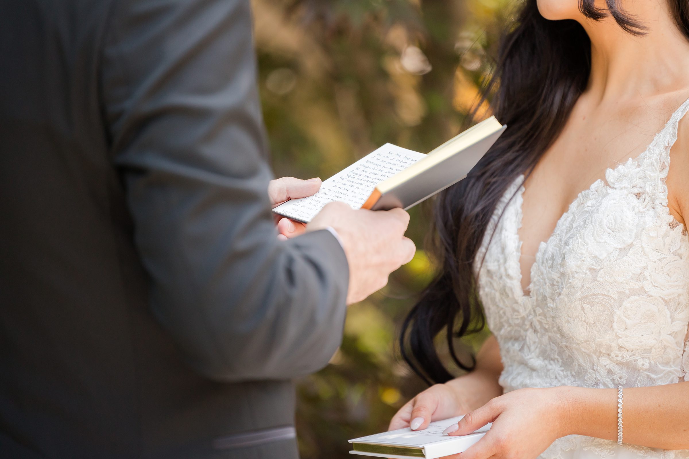 A close-up shot of bride and groom holding each other's vow notes. 