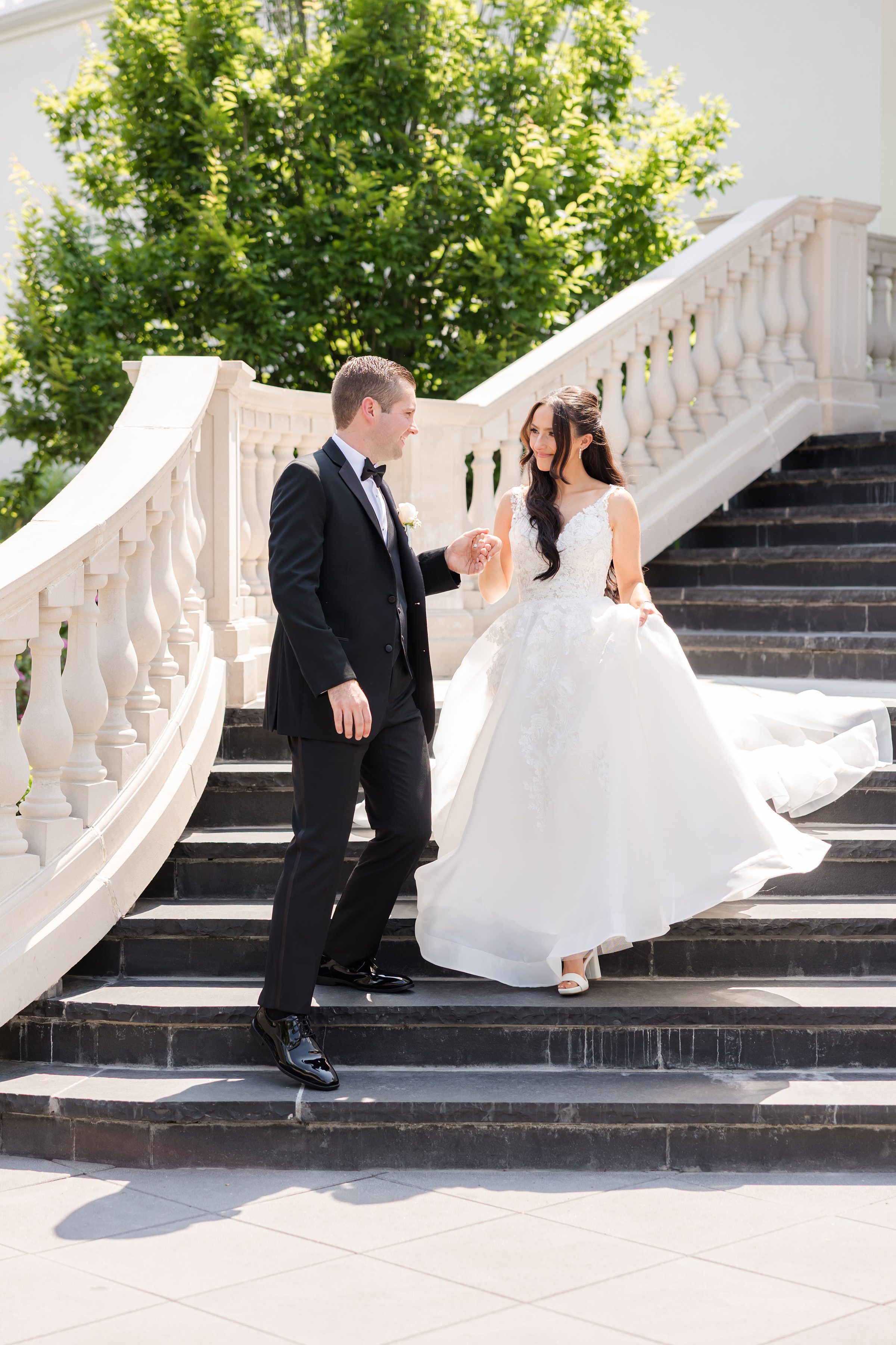 Groom is holding the bride's wife while walking down the stairs.