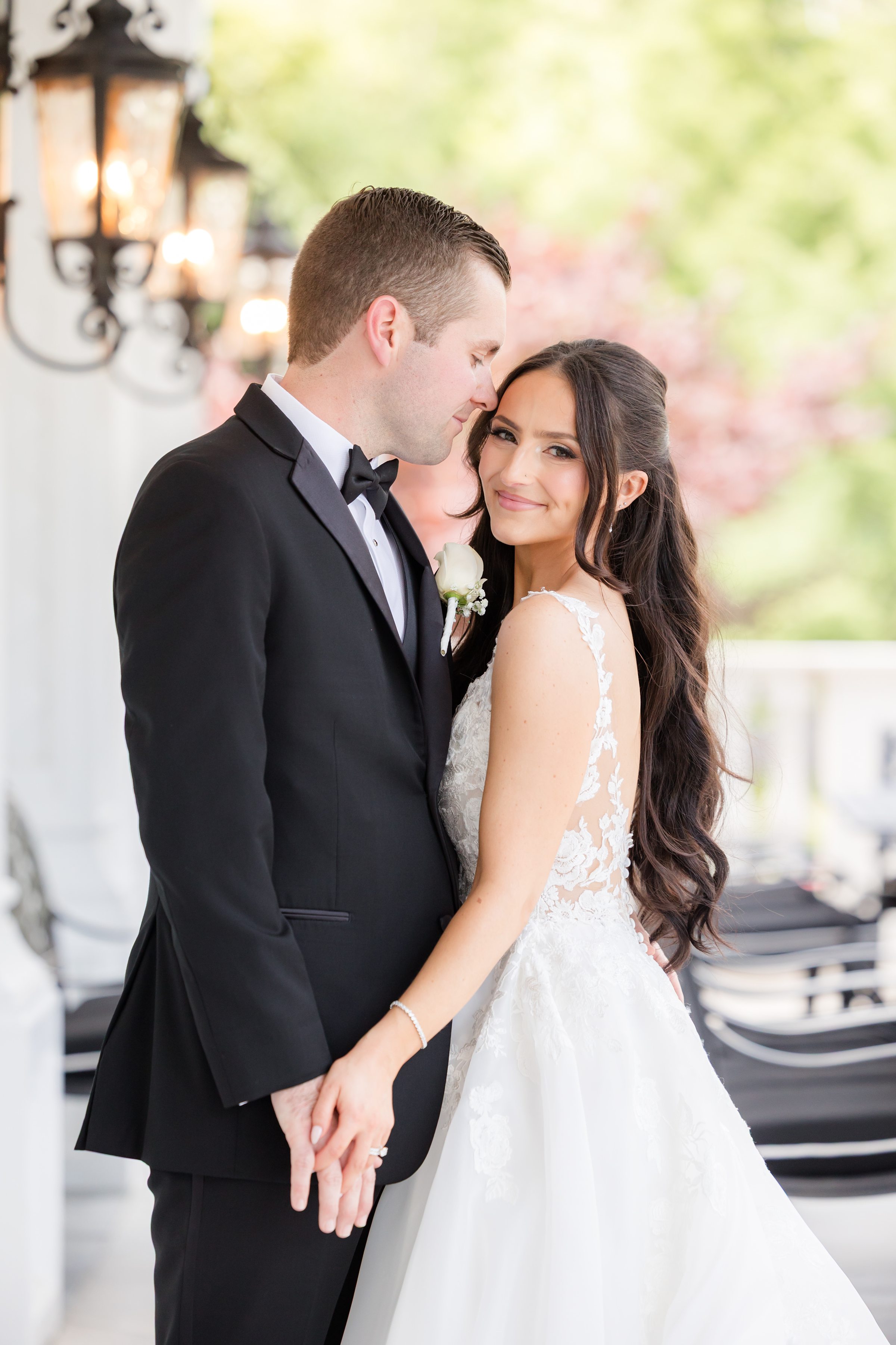 Groom is looking at the bride while the bride is smiling at the camera