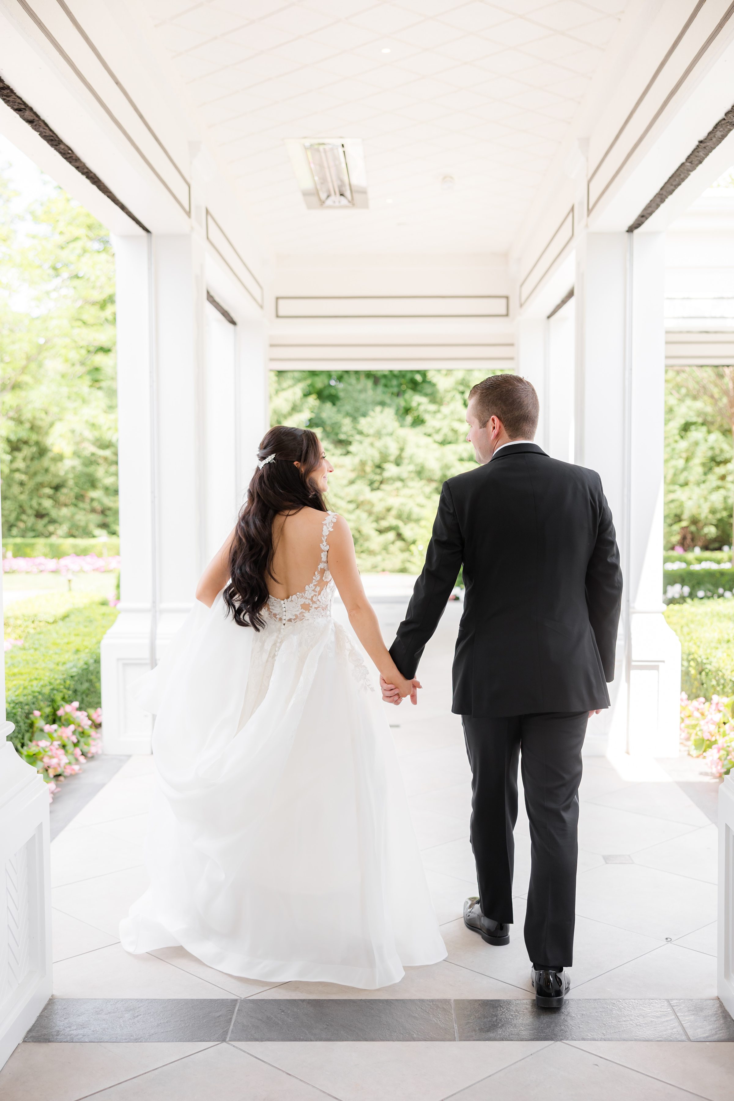 A backshot of groom and bride holding hands together