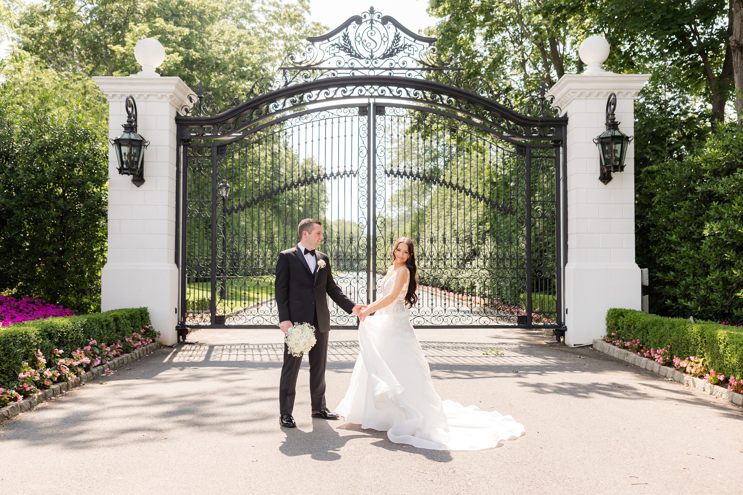 Bride and groom are holding hands together by the gate