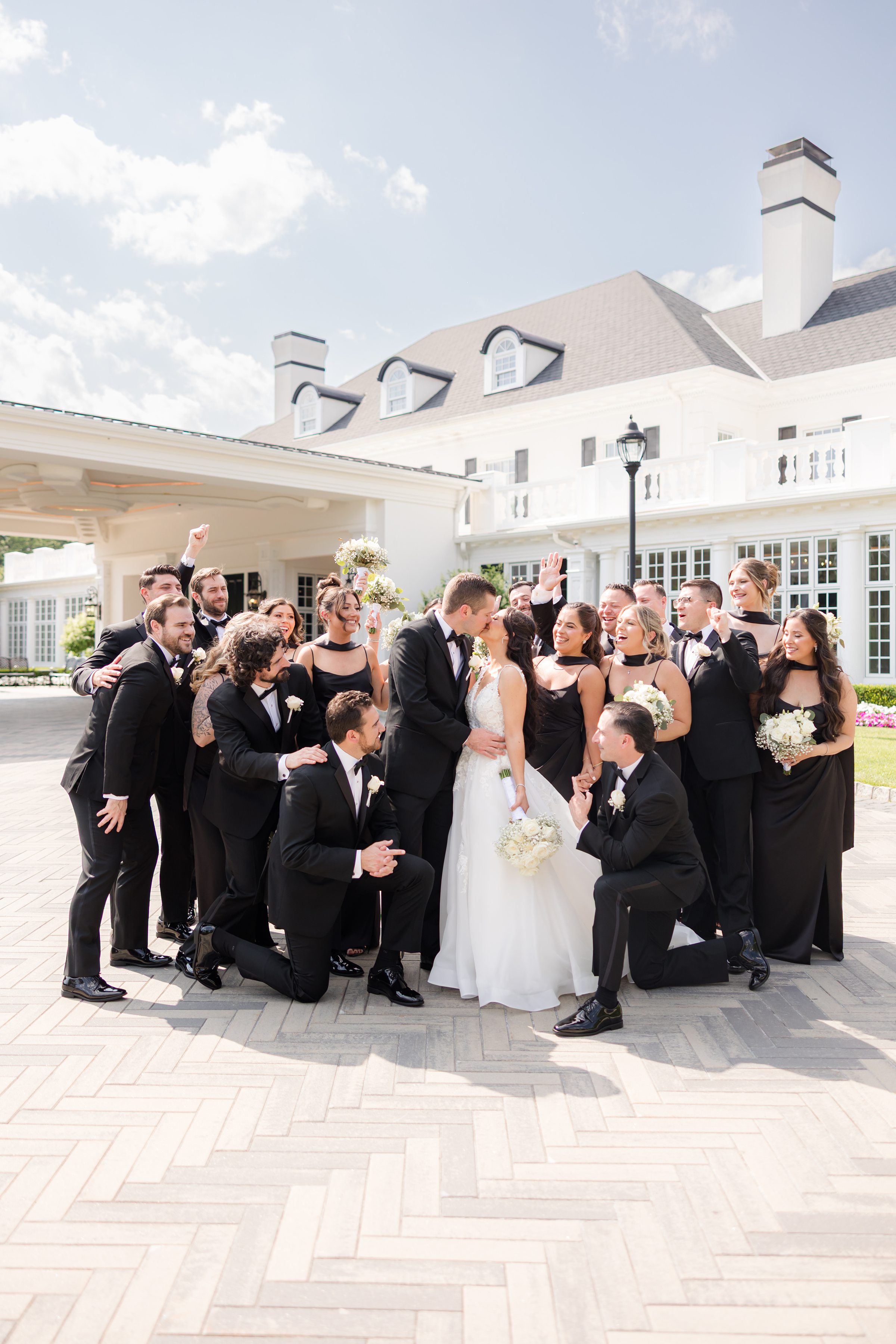 Bridesmaids and groomsmen are cheering for the couple as they kiss together