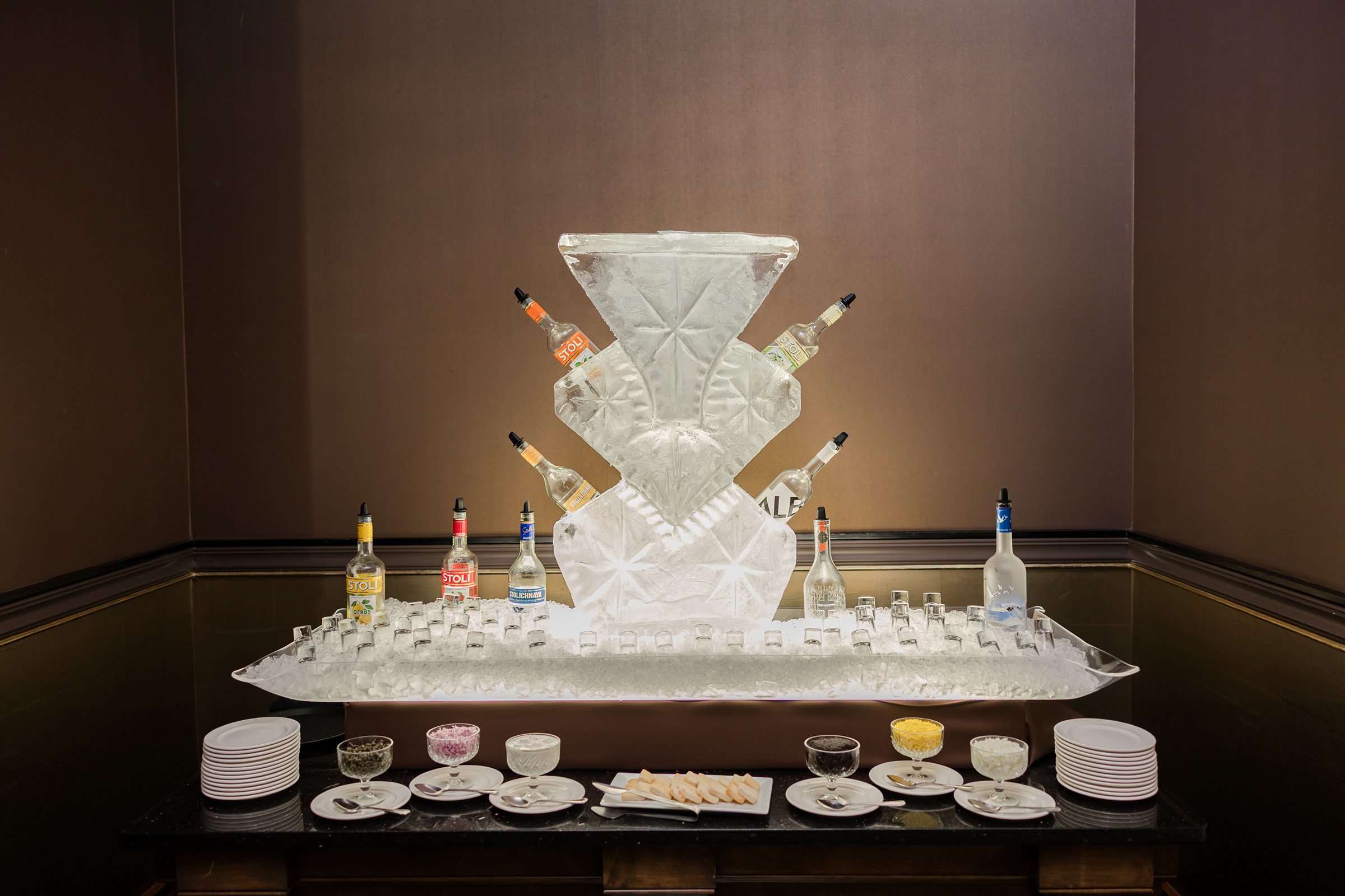 A picture of Vodka drinks placed in a luxury organizer together with mini plates and desserts