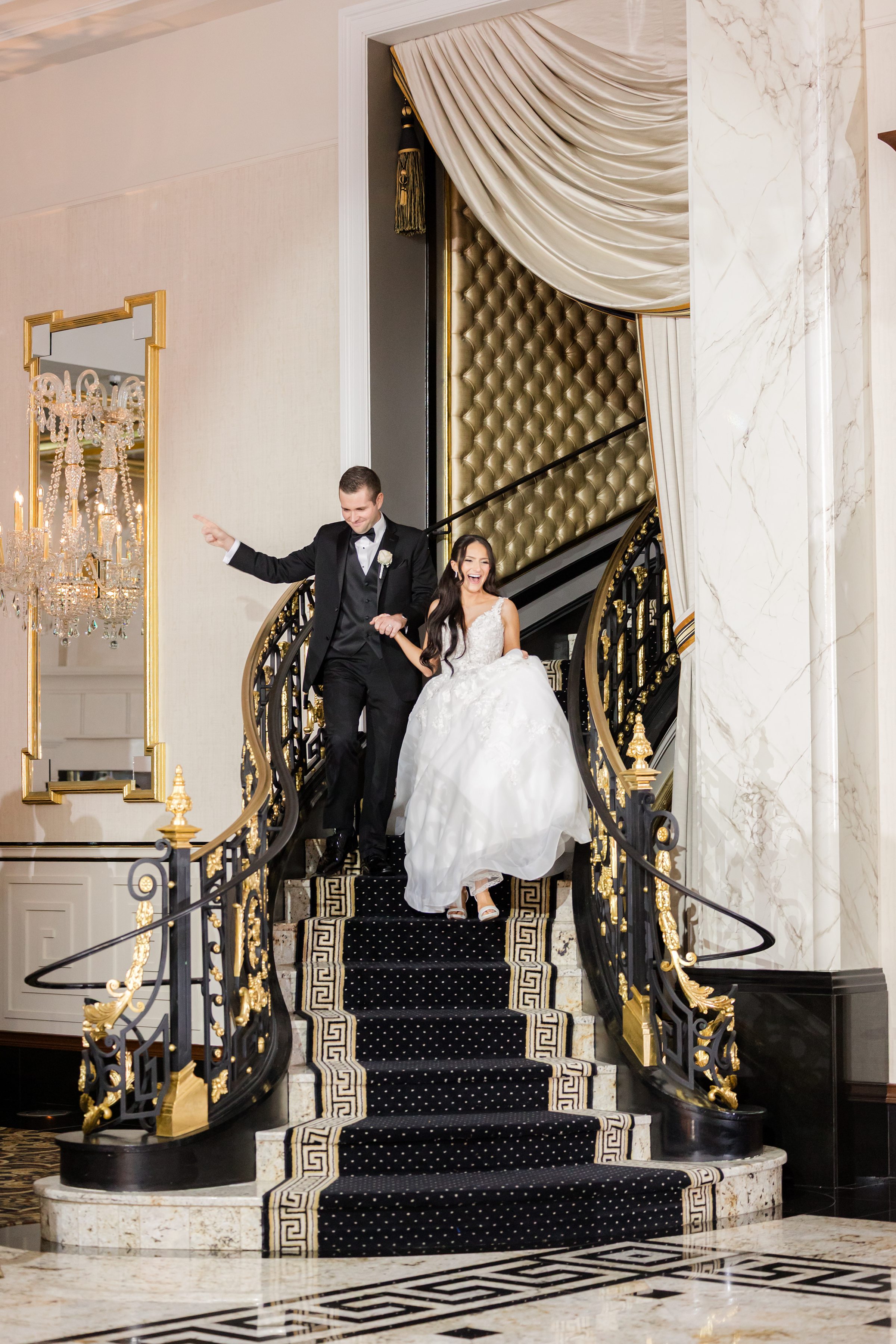 Bride and groom going down the stairs to reception hall