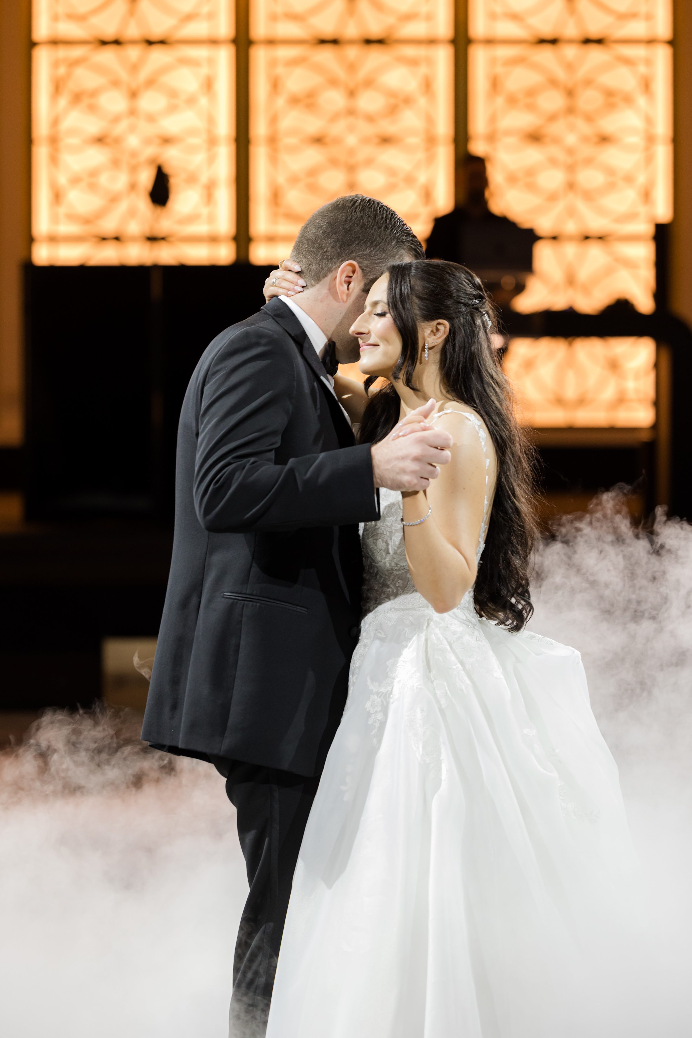 Getting close together as they dance, with smoke in the background 