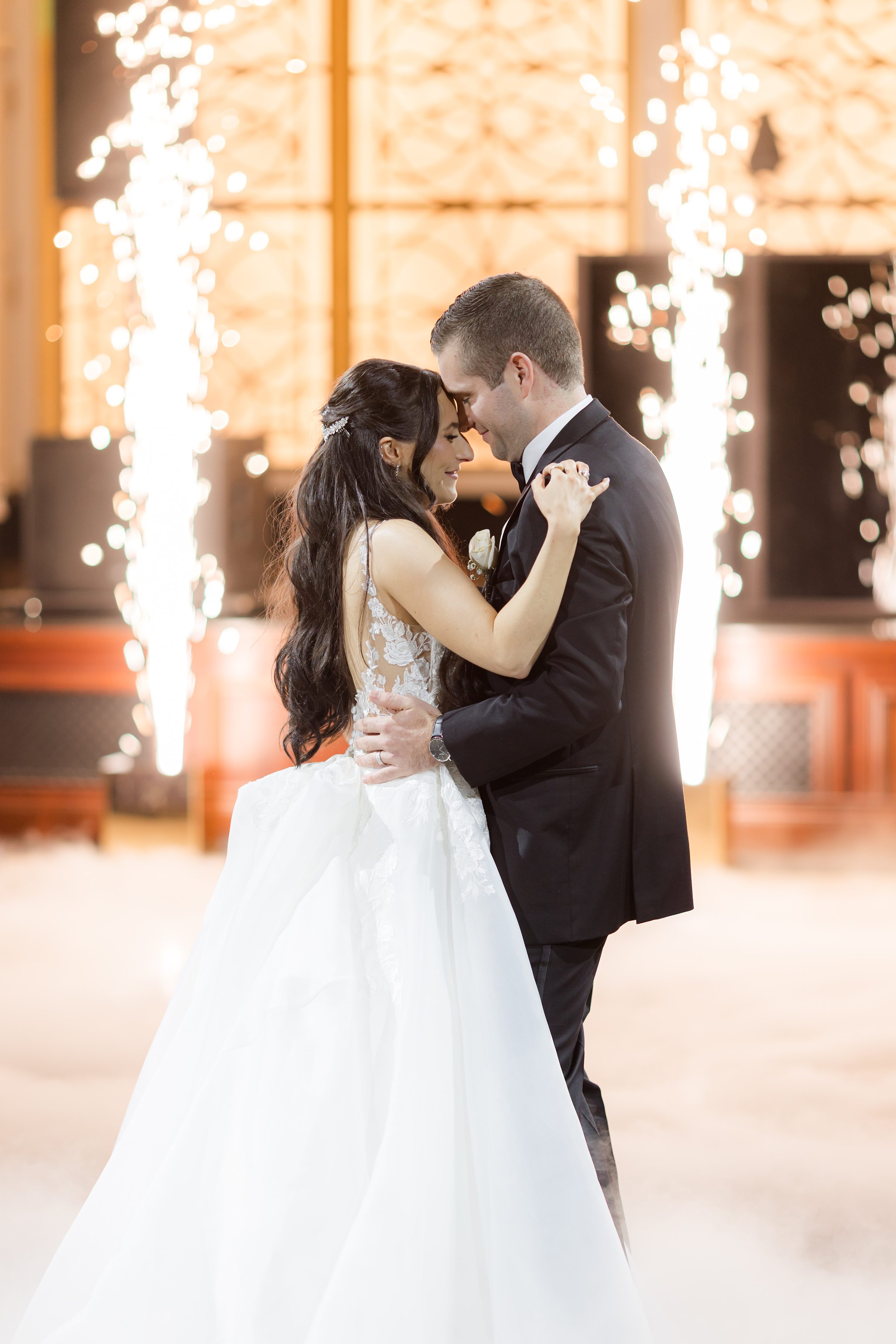 A close-up shot of the couple holding each other with some smoke and mini fireworks
