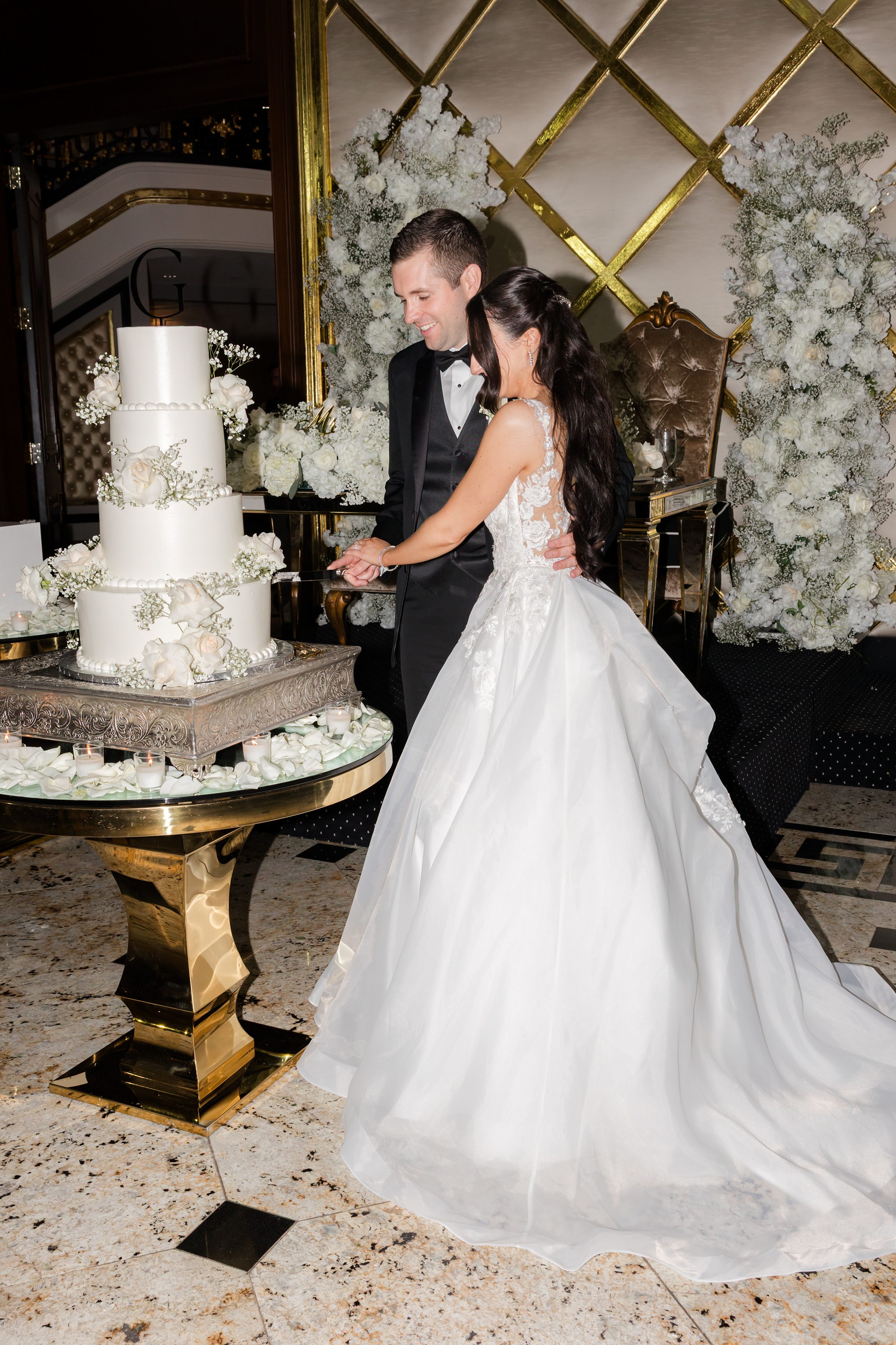 Slicing the 4 layers of white wedding cake together