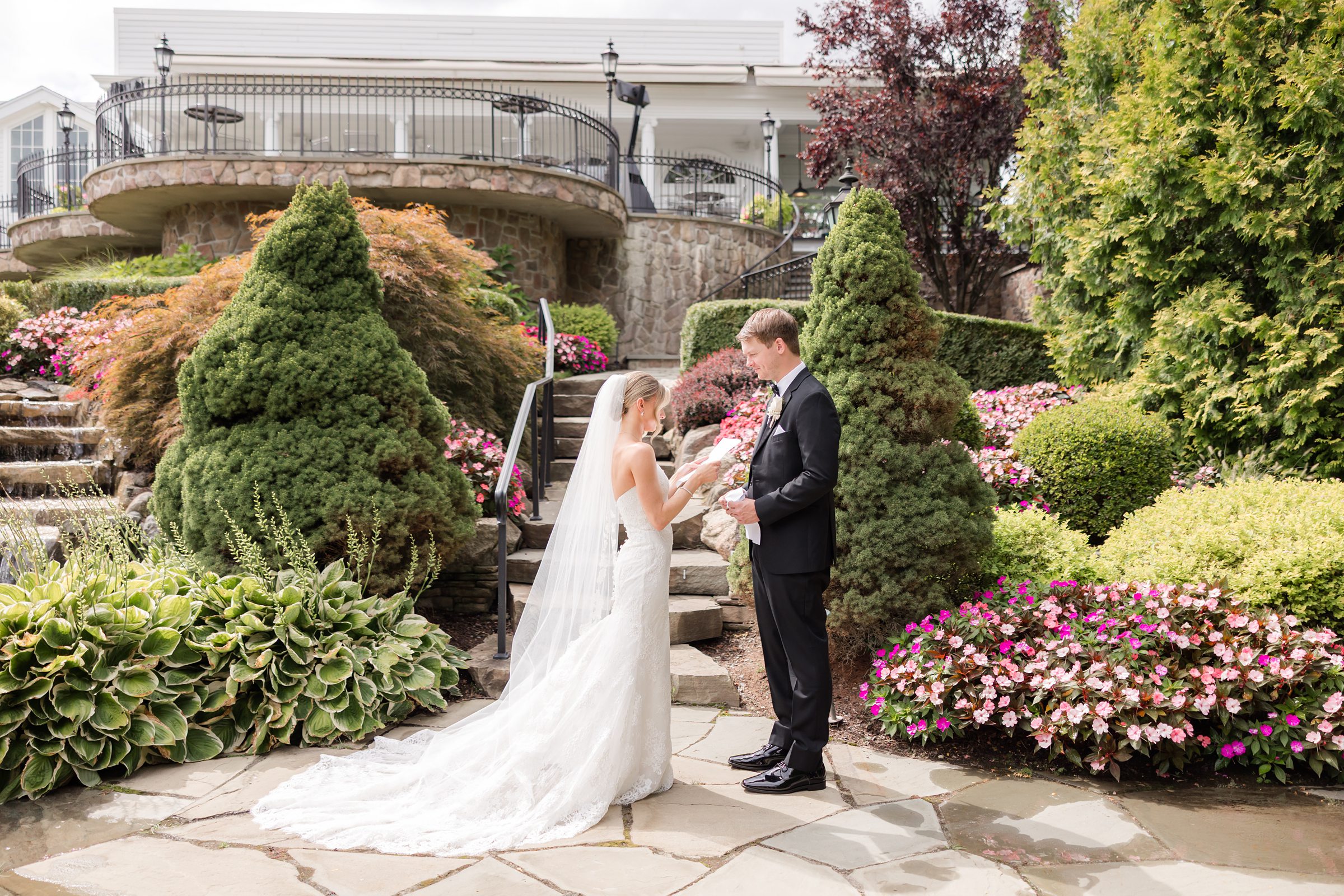 Landscape photo of bride reading her vows to her groom in the garden at Park Savoy
