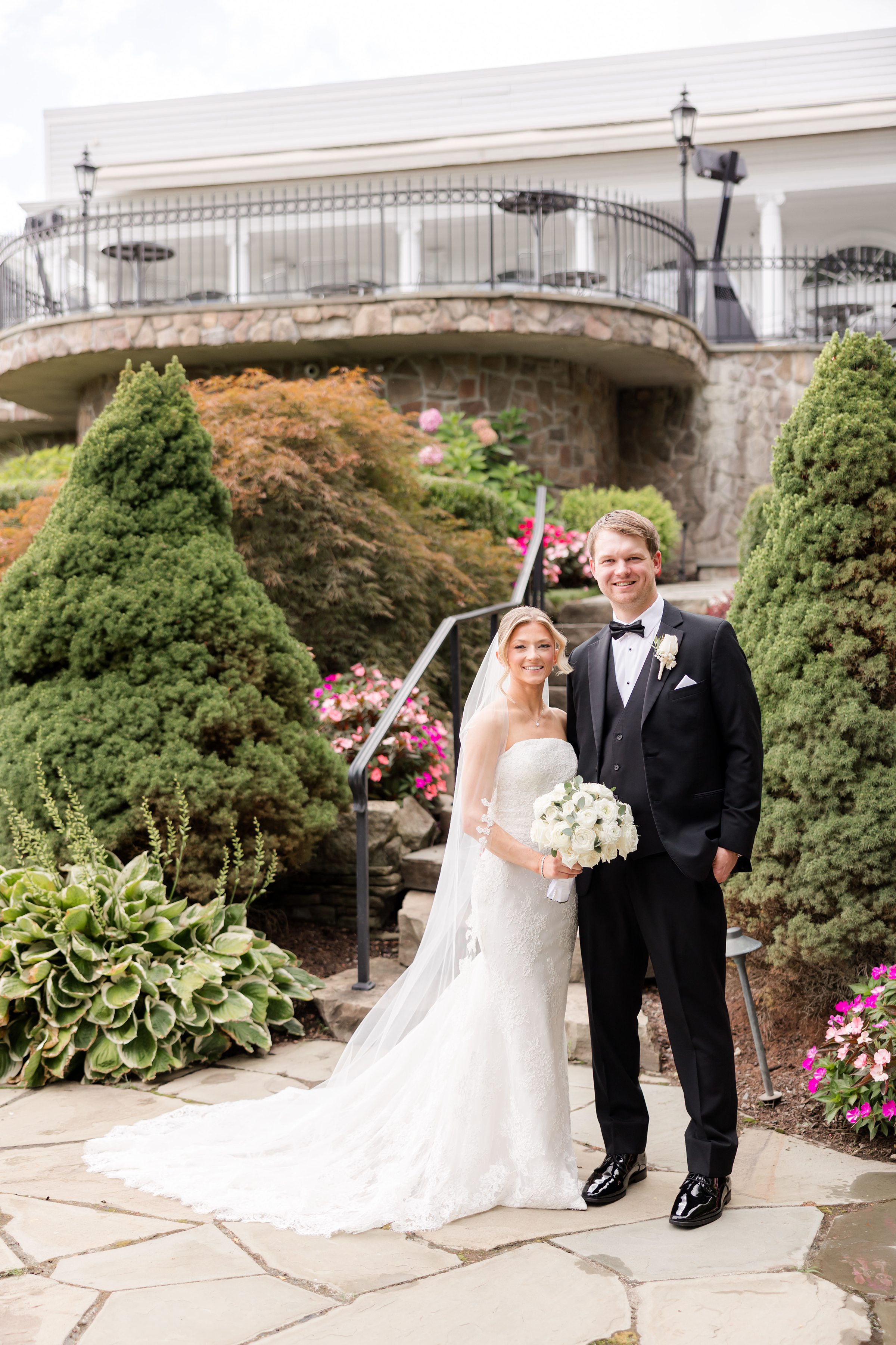 Portrait of bride and groom below the stairs at Park Savoy's garden. Bride is holding her bouquet with her right hand while the groom is holding her by the waist
