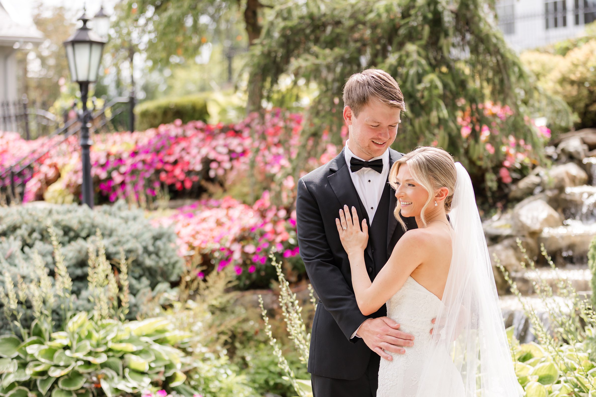 Landscape photo of the the groom looking down to the bride while the bride is holding his chest, looking to the left