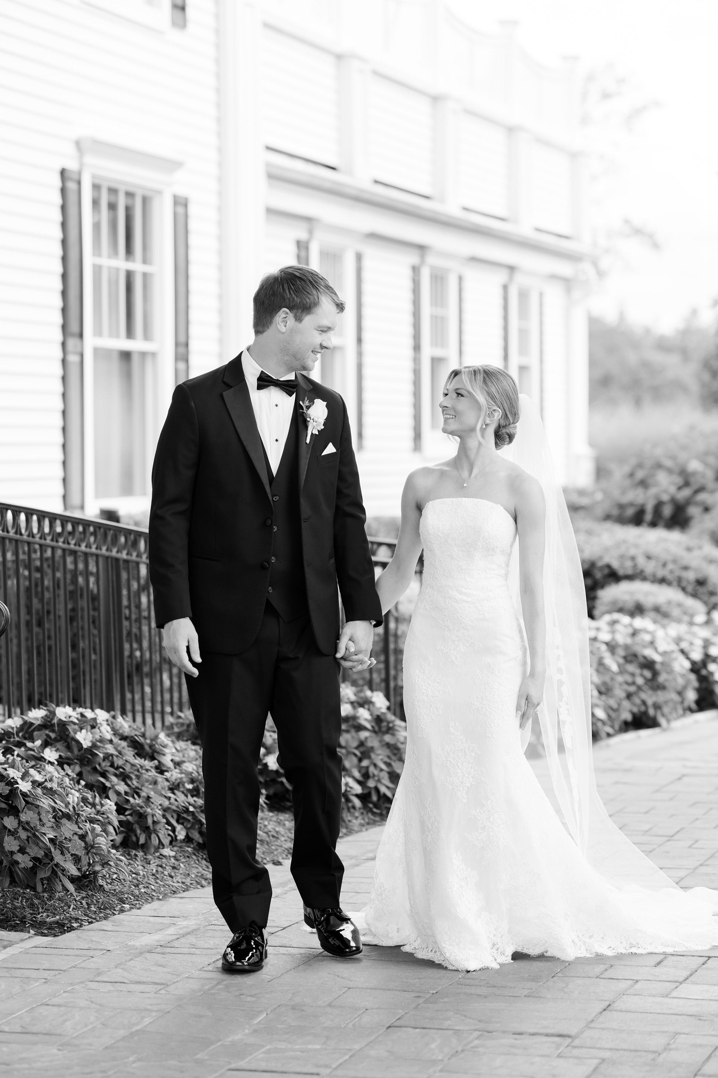 Black and white photo of the bride looking at each other while holding hands at Park Savoy's entrance