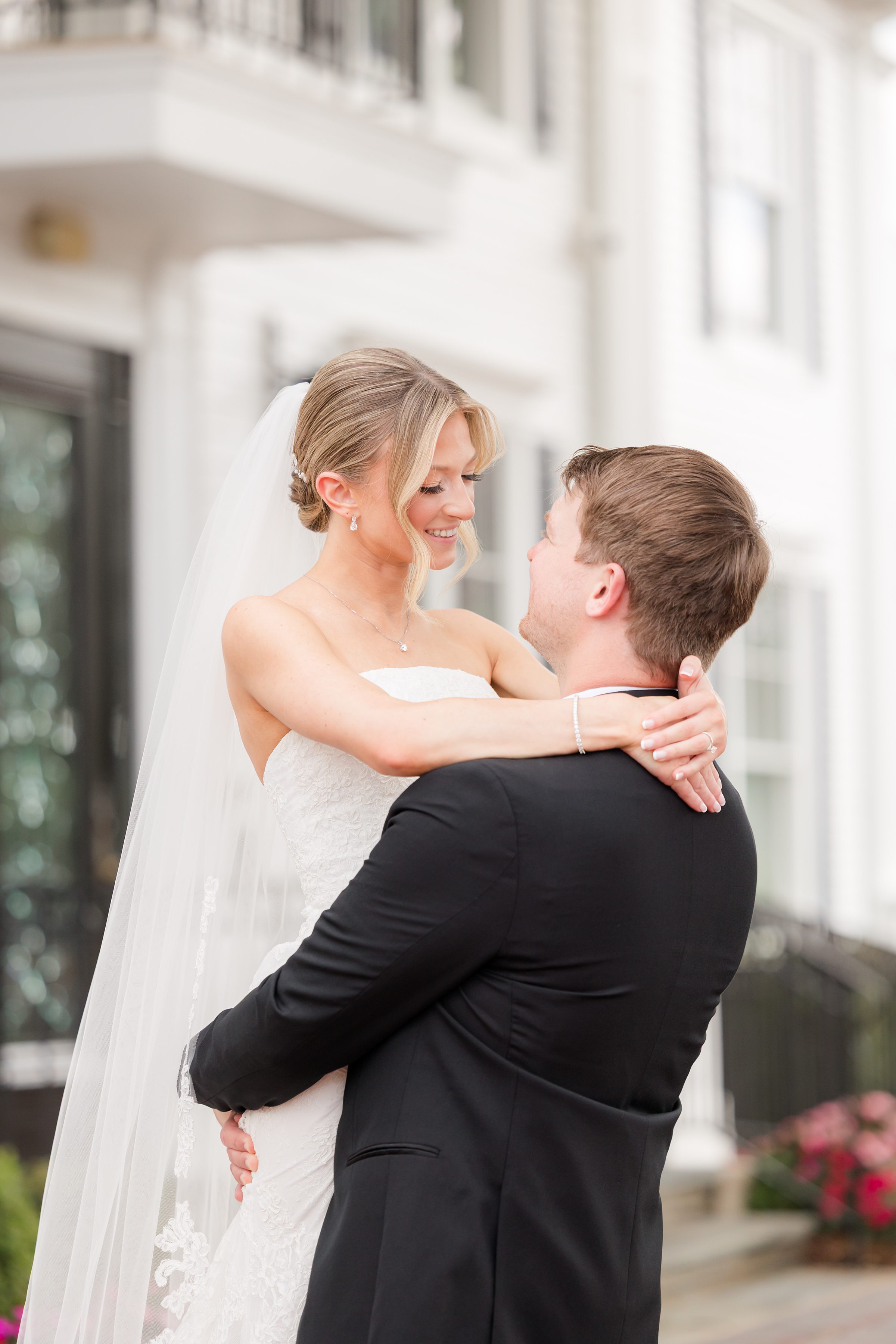 Groom carrying the bride while she wraps her hands around his neck