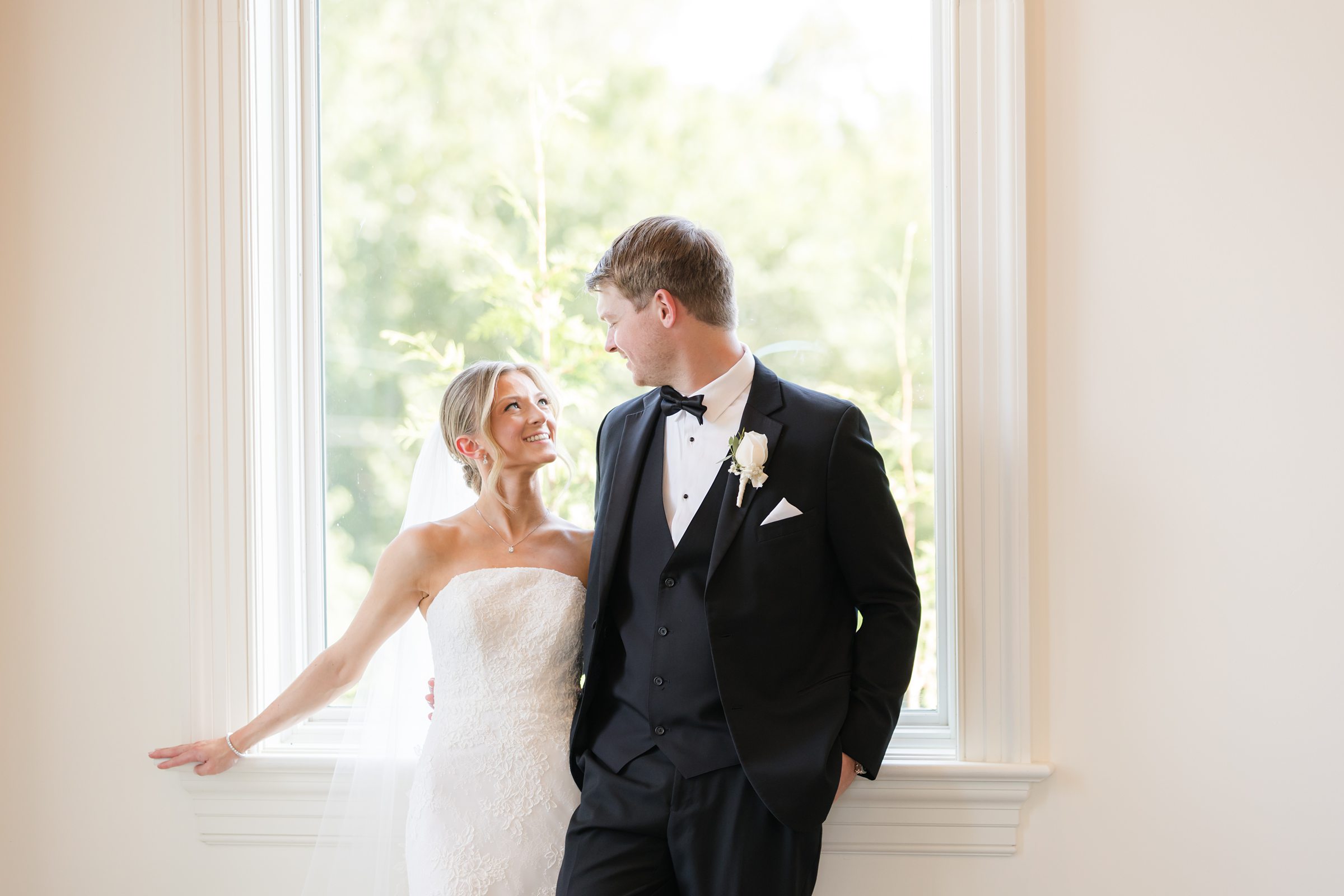 Landscape photo of bride and groom by the window looking at each other