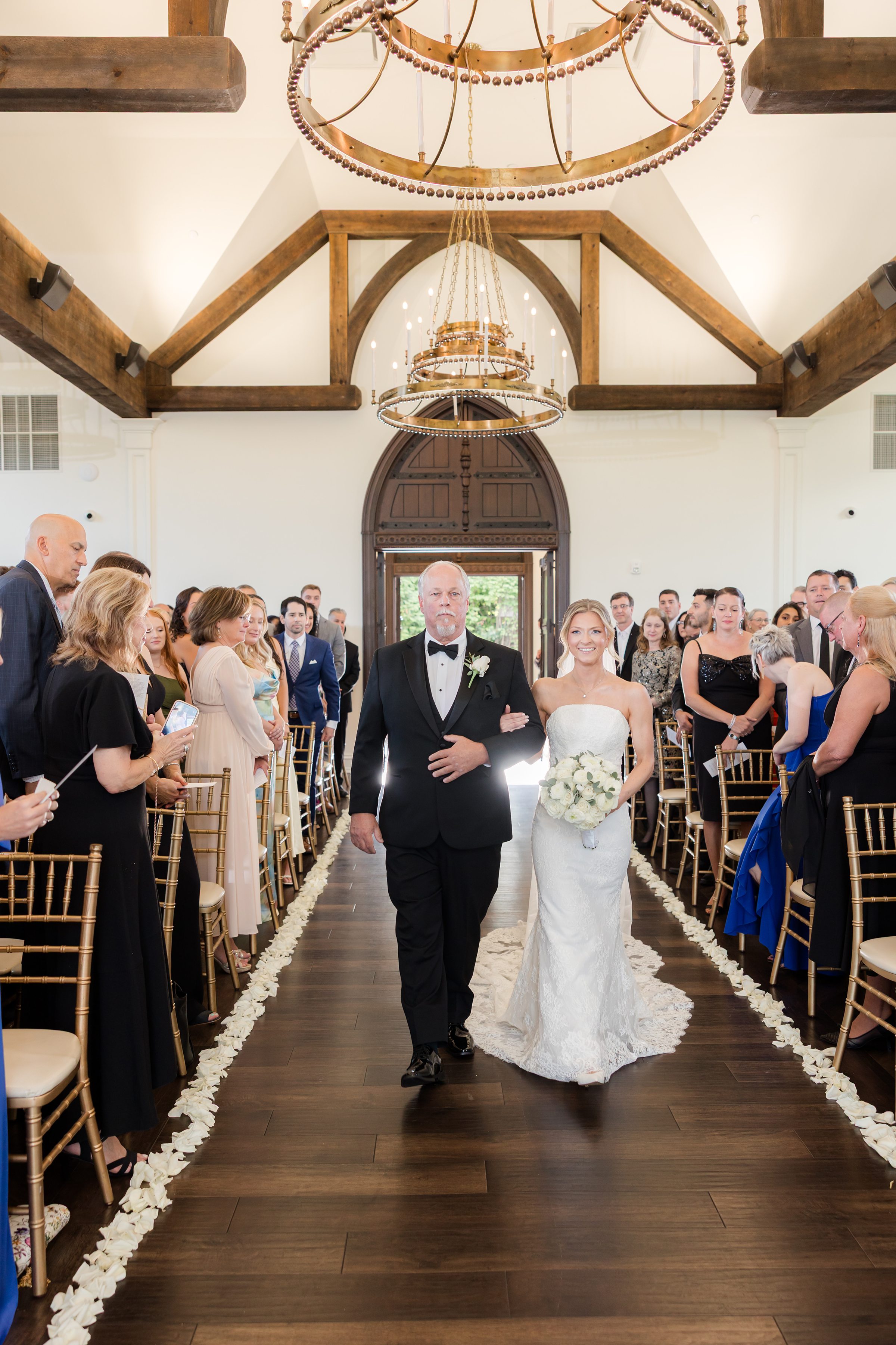 Bride walking down the wooden aisle with her dad to her right