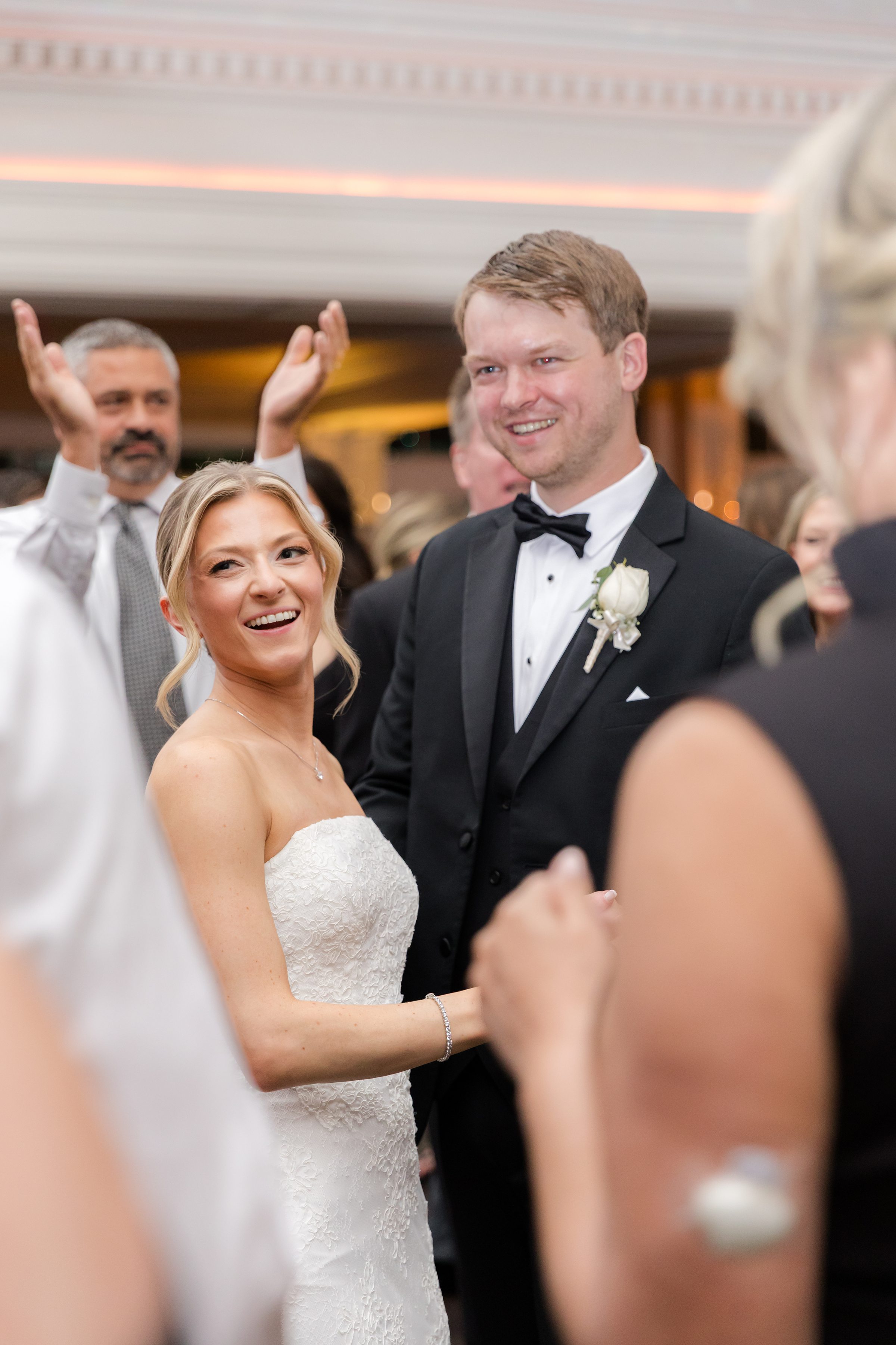 Focused photo of bride and groom smiling at their guests