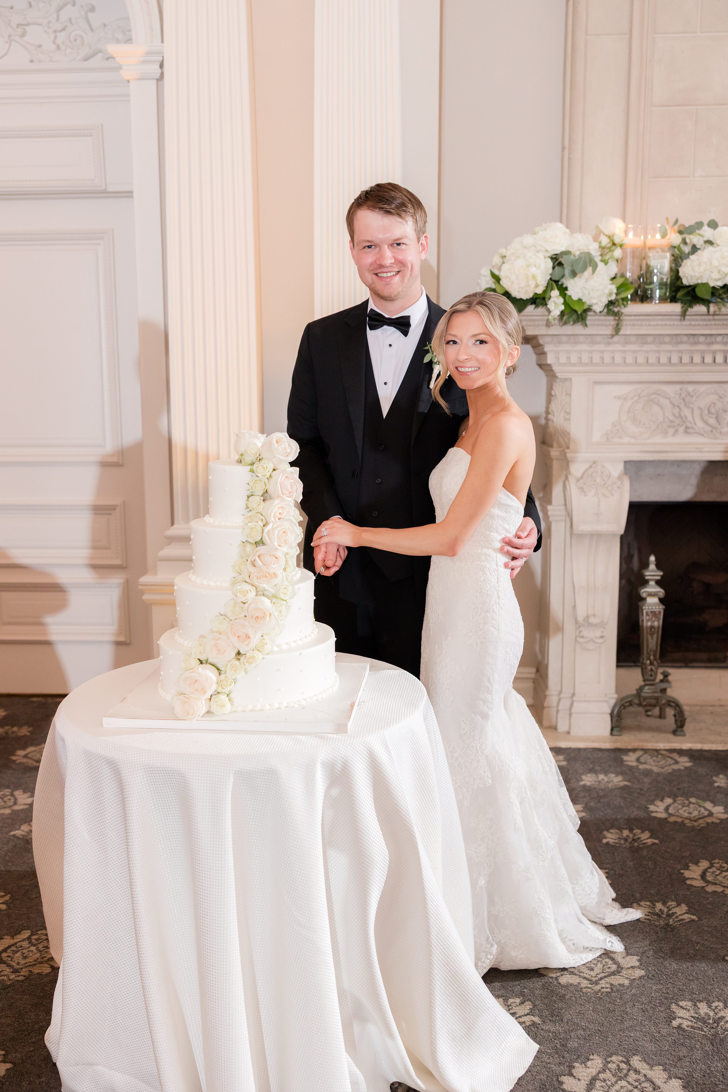 Bride and groom smiling at the camera before cake cutting