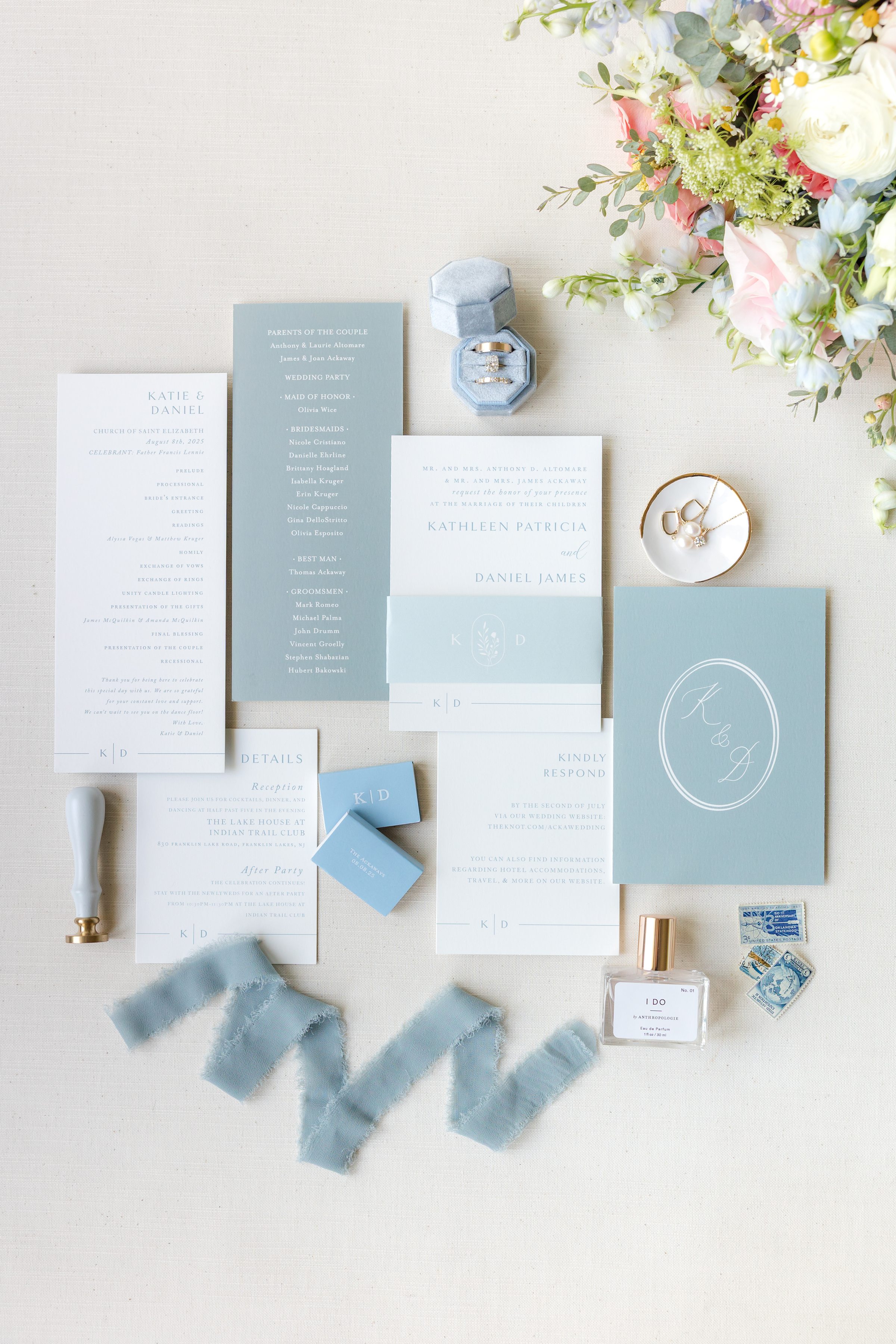 detail shot of wedding invites and bridal details with white and powder blue palette with flowers in the upper corner