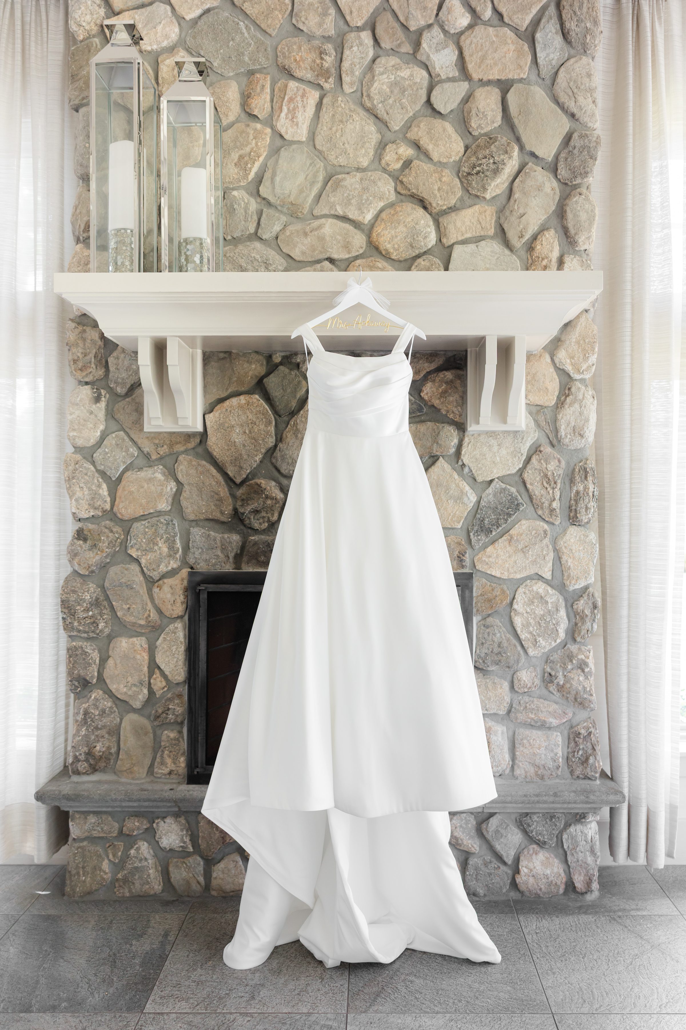 a photo of white wedding dress hanging on a shelf 