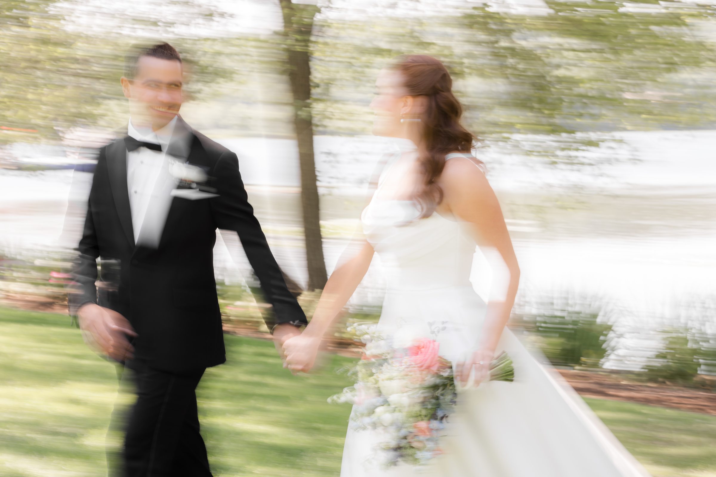 landscape blurry shot of bride and groom by the tree 