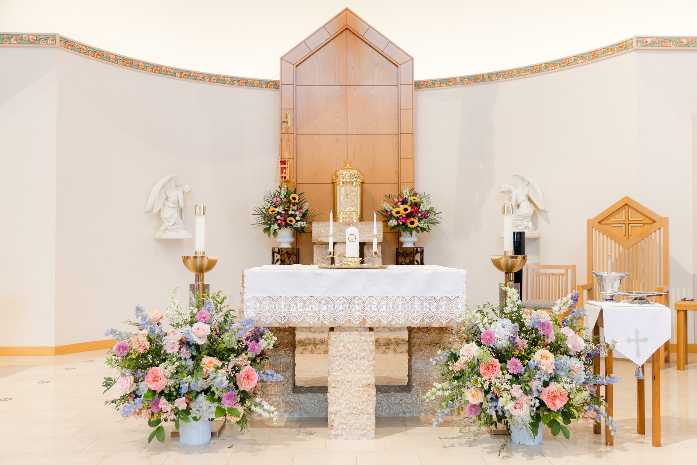A detail picture of the church altar with orange, blue, pink, white flowers