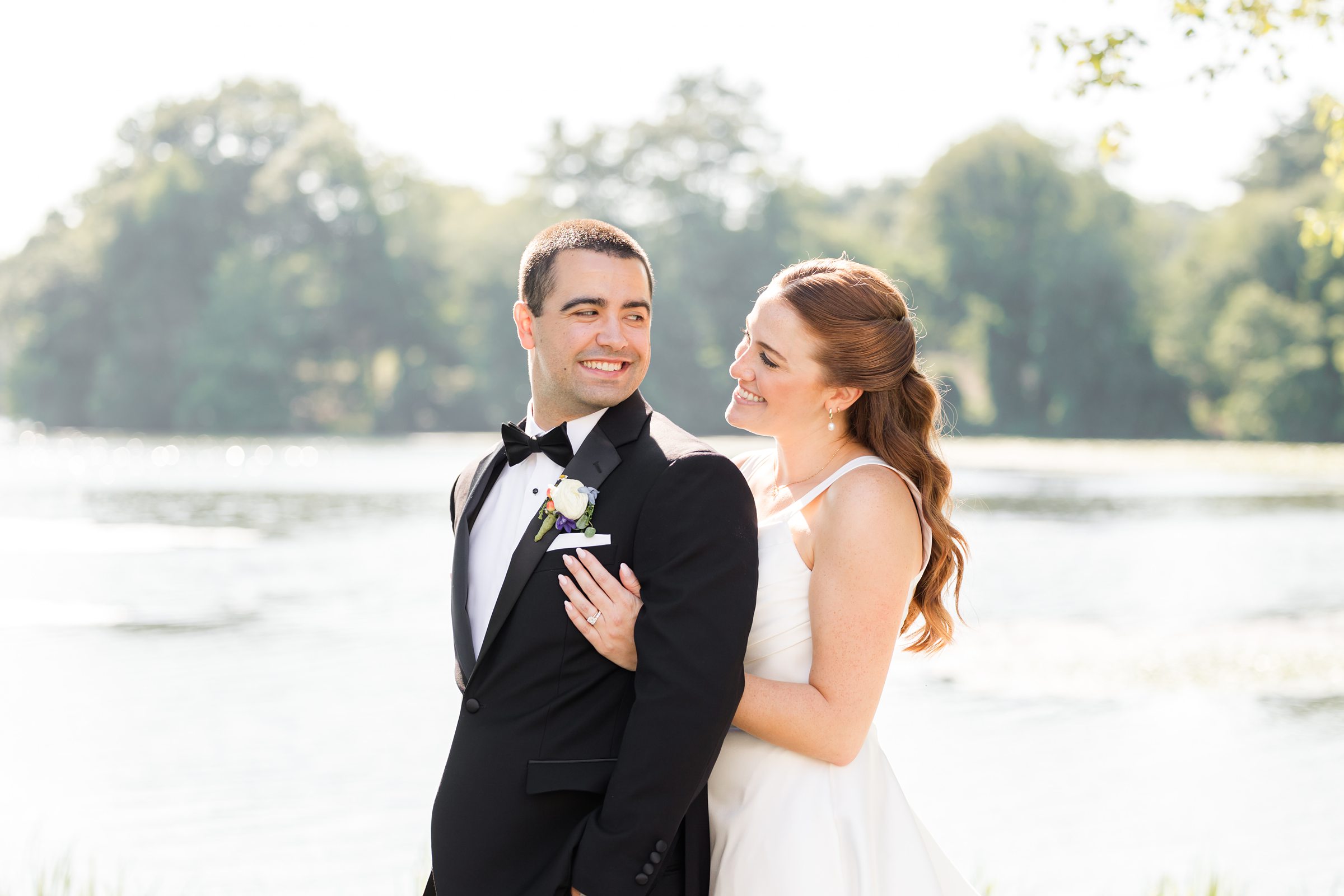 a half-body picture of bride and groom while the groom is smiling back to his bride