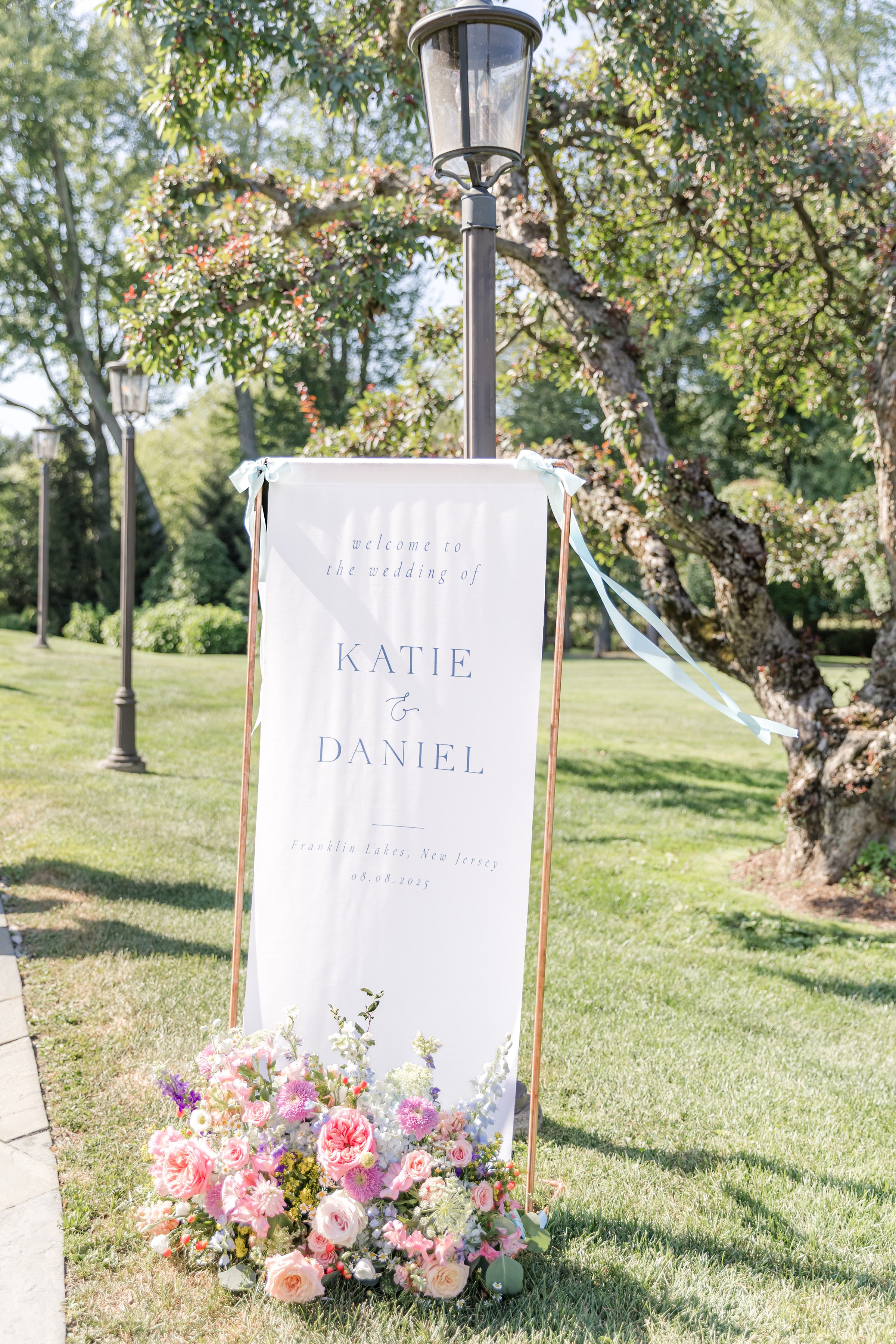 a detail shot of wedding post with pink, lavender, green, white flowers 