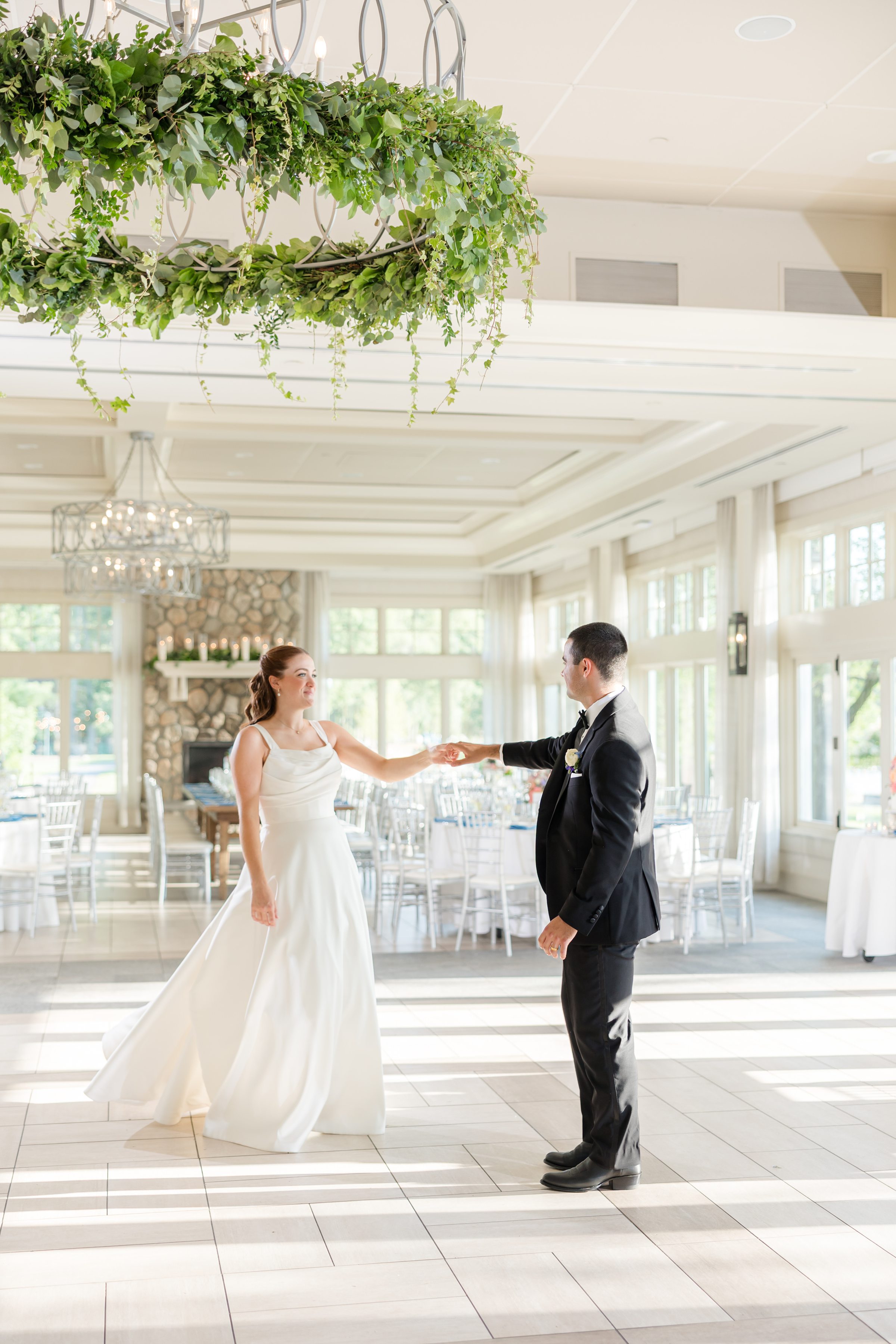 bride and groom rehearsing first dance in an empty ball room