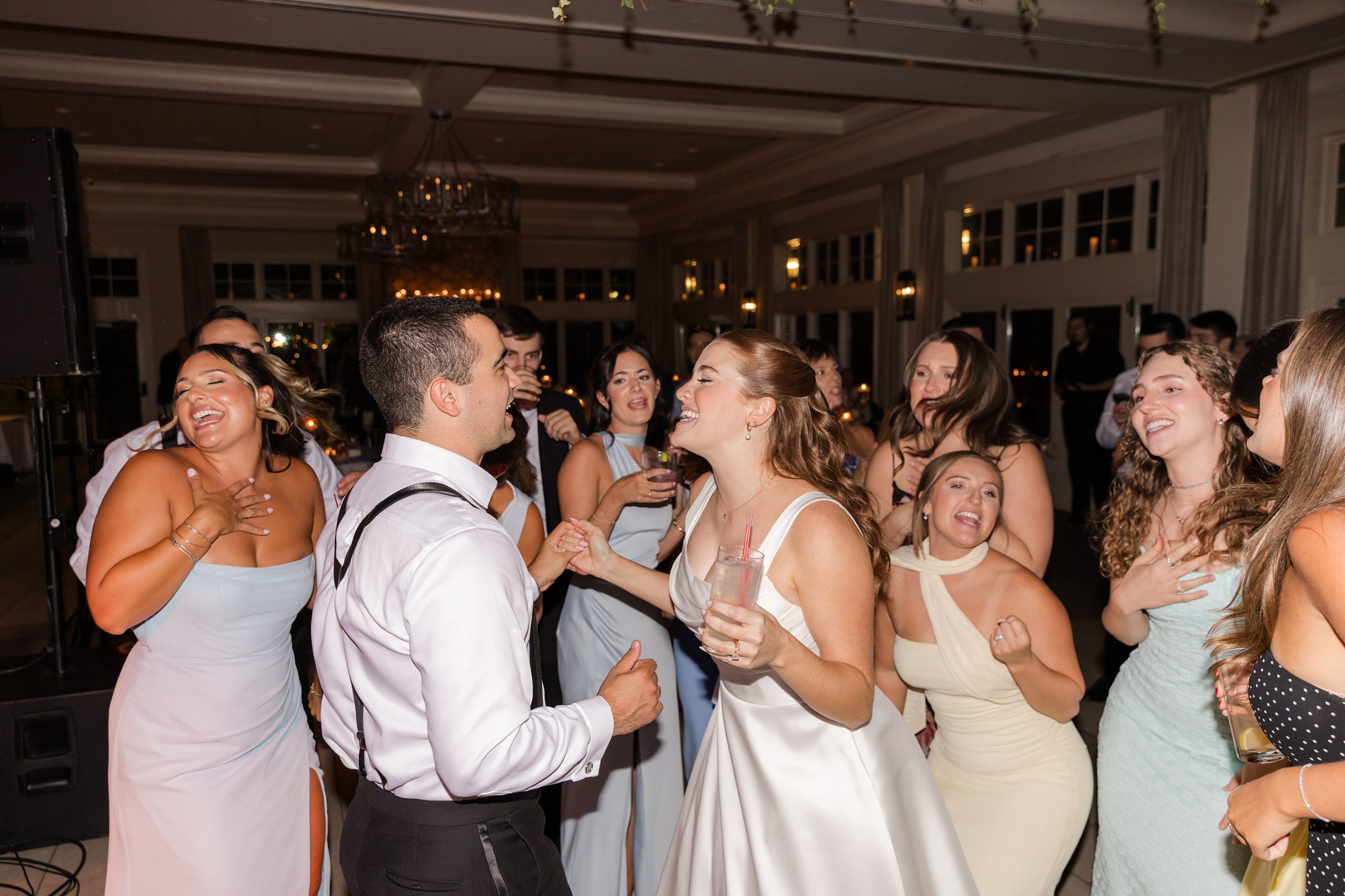 landscape photo of bride and groom dancing with guests 