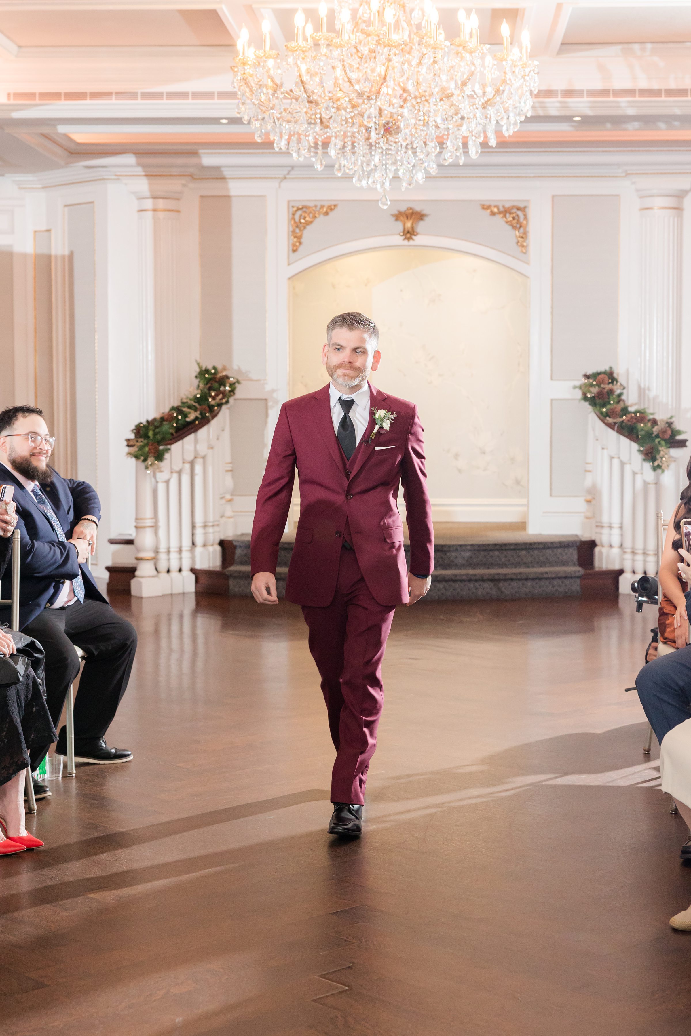 Groom confidently walks down the aisle, anticipation and joy evident in his expression.