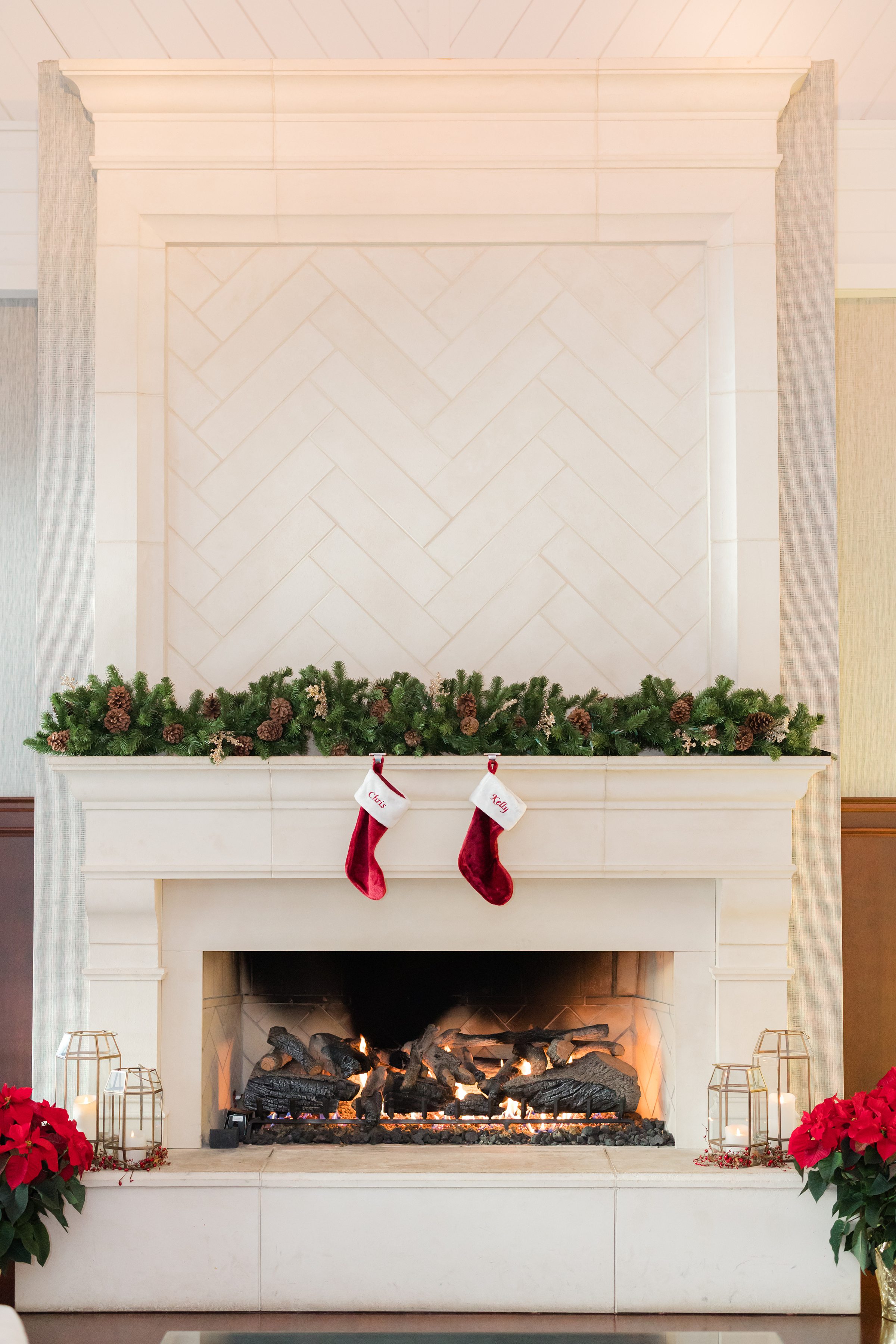 Softly glowing fireplace adorned with evergreen garland and stockings, creating a warm and intimate holiday ambiance.