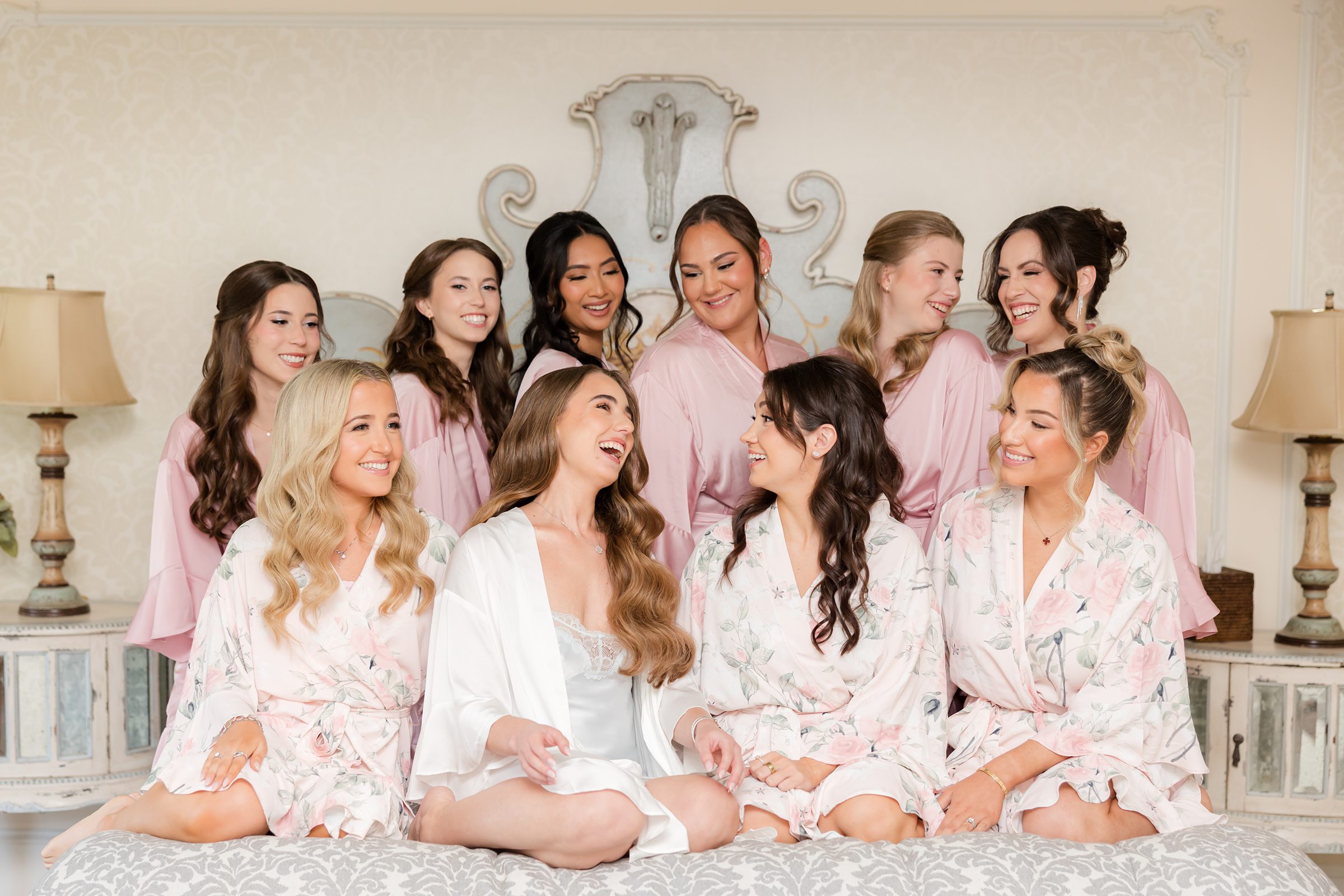 Bride laughing with bridesmaids on the bed