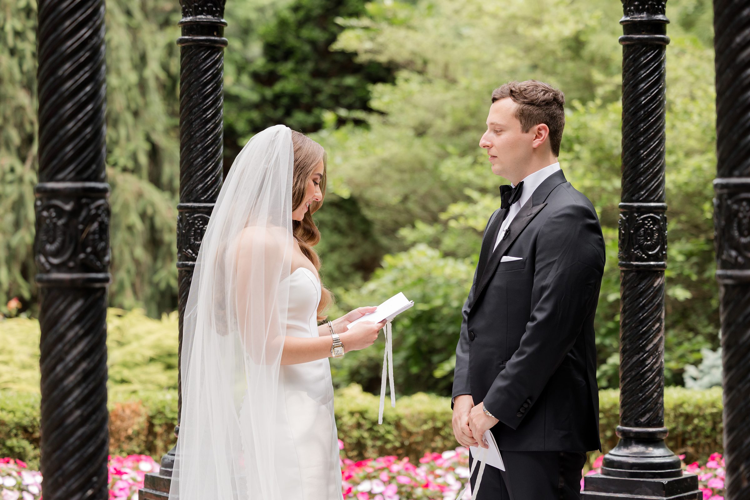 Bride reading her vows to her groom while the groom looks at her