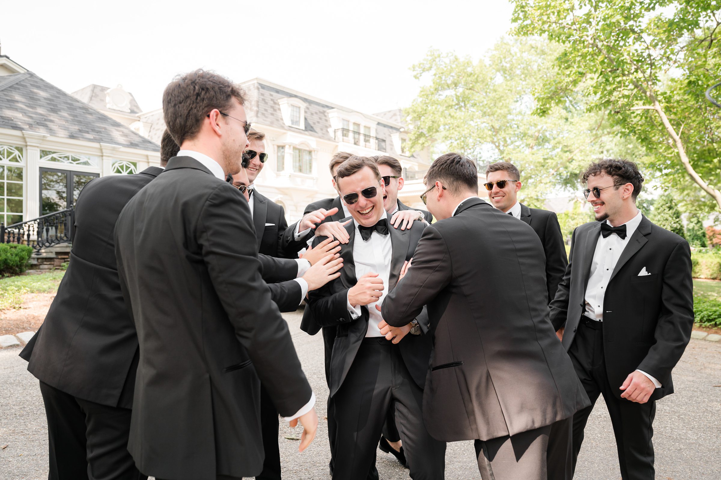 Groomsmen teasing the groom while they're all wearing sunglasses