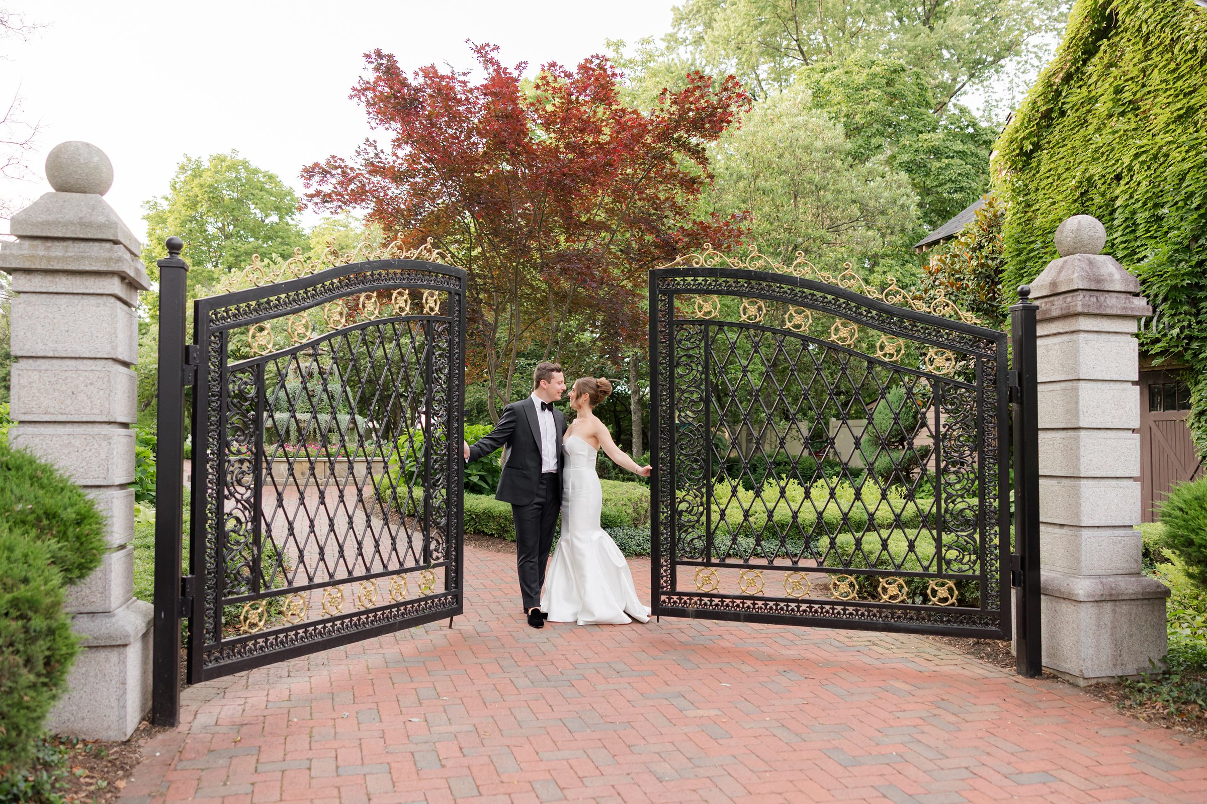 Bride and groom standing by the gate of ashford estate