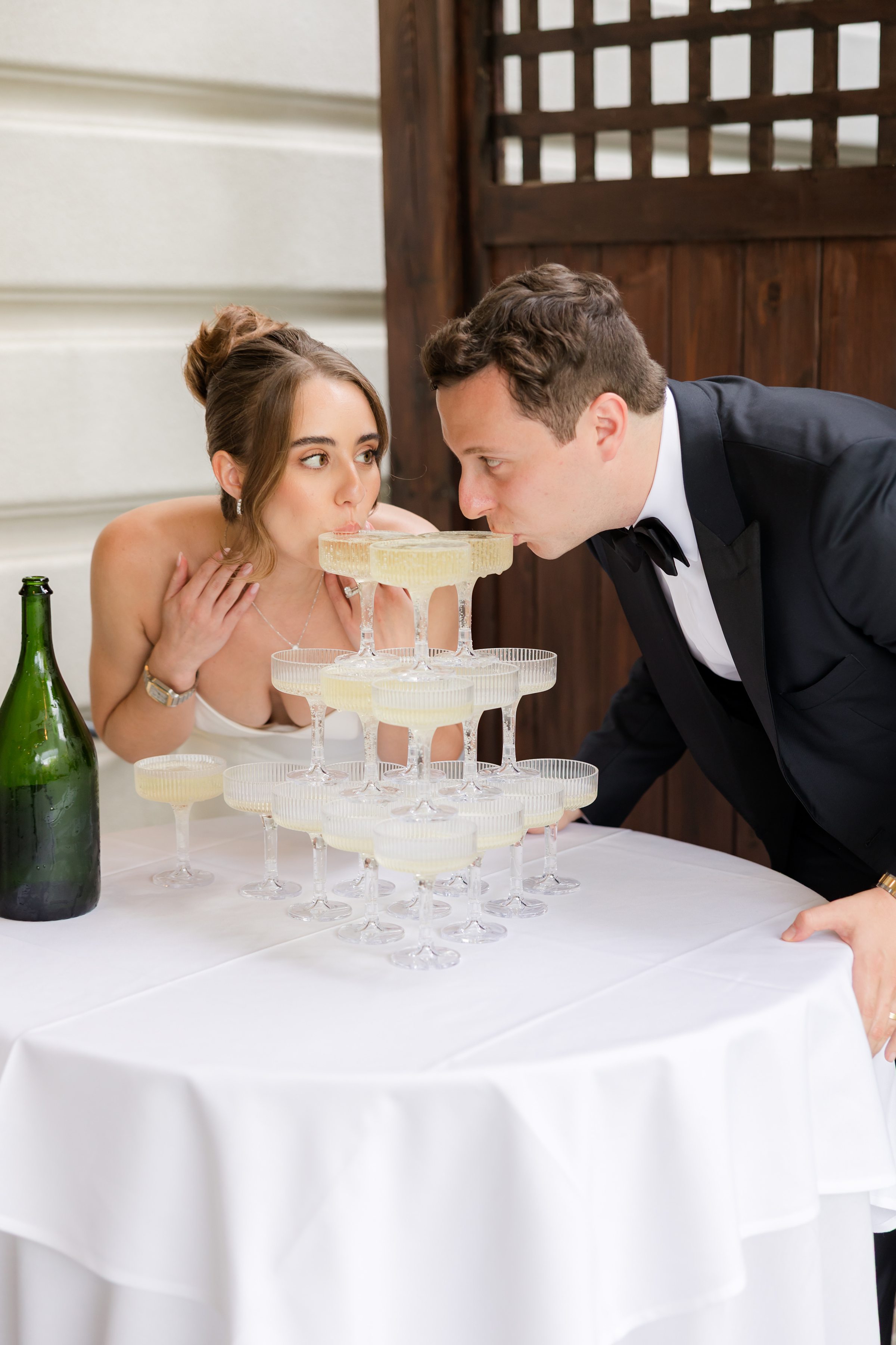 Bride and groom sipping champagne together.