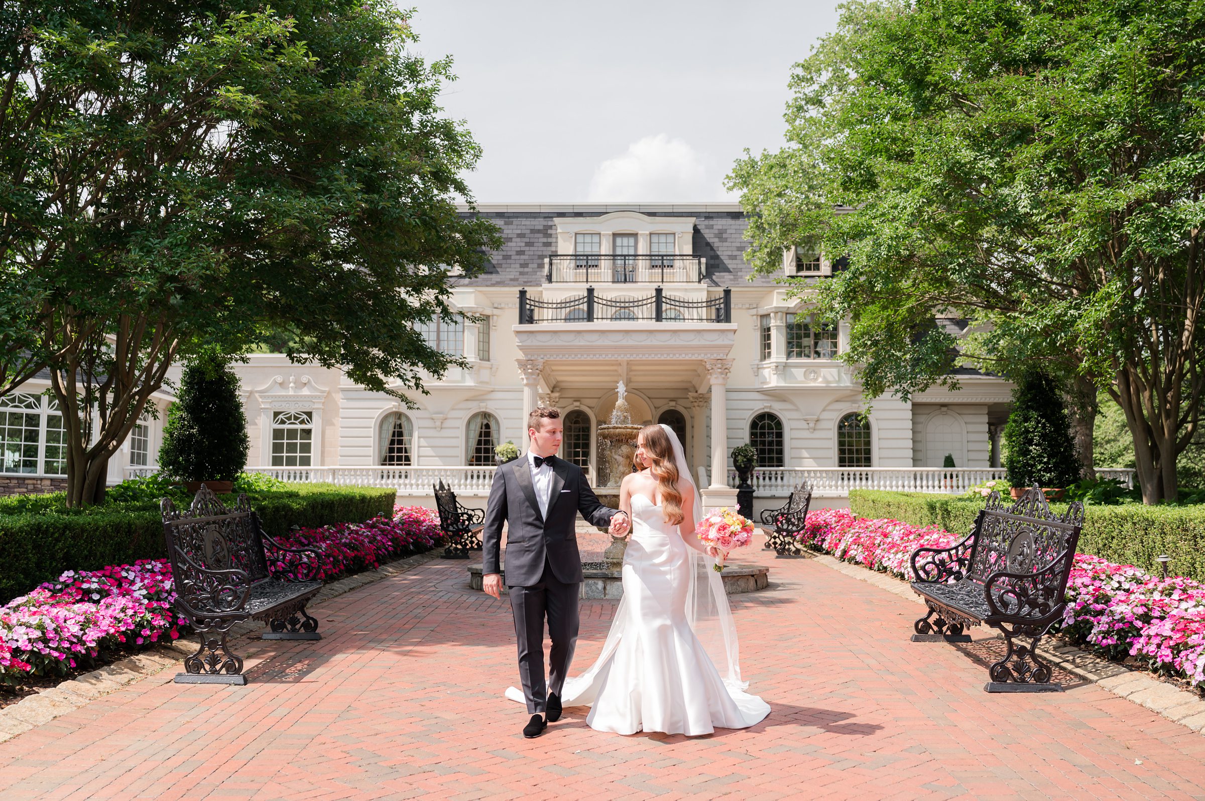 Bride and groom looking at each other while holding each other's hands in front of Ashford Estate. 