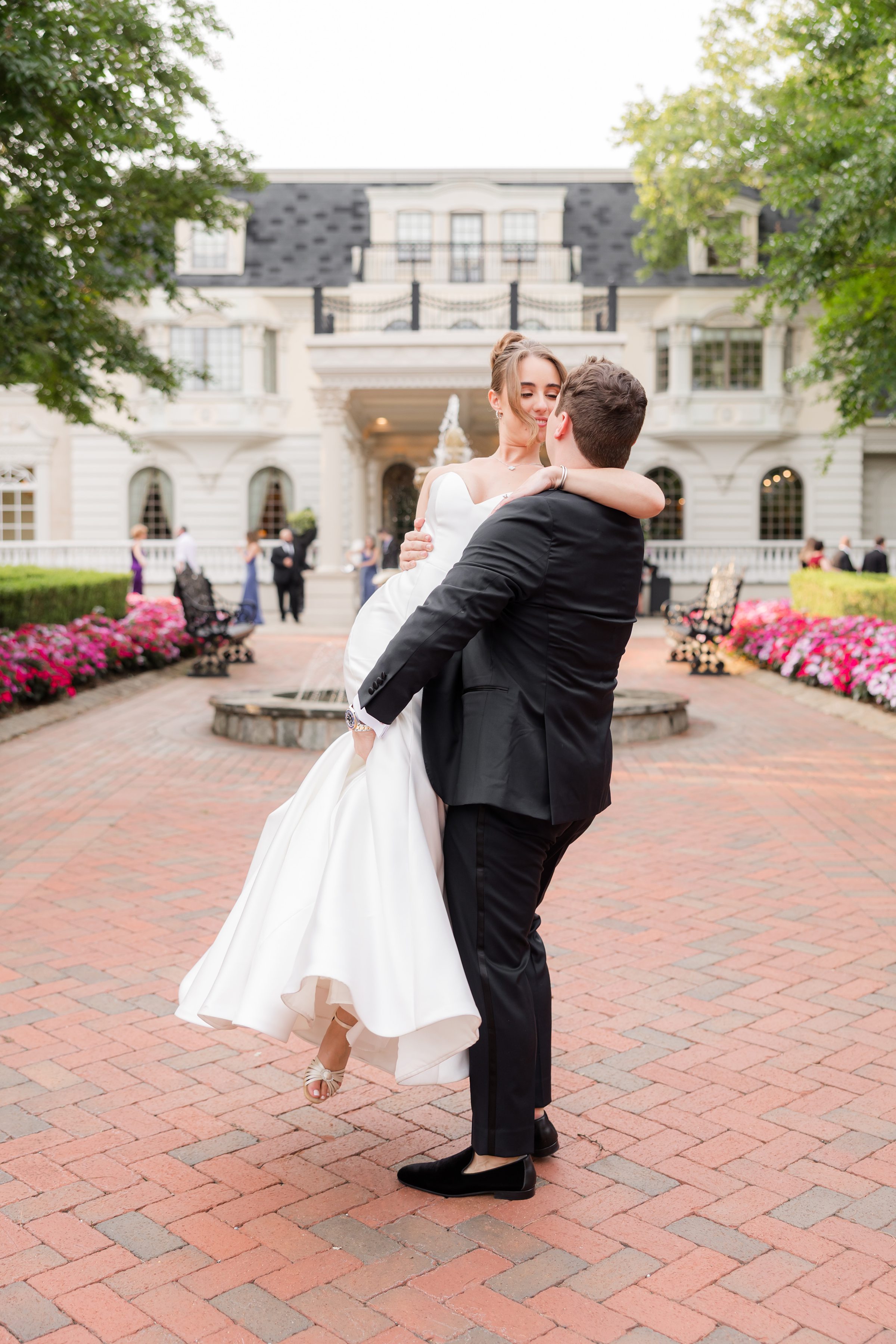 Bride and groom looking at each other while the groom is carrying the bride in front of Ashford Estate