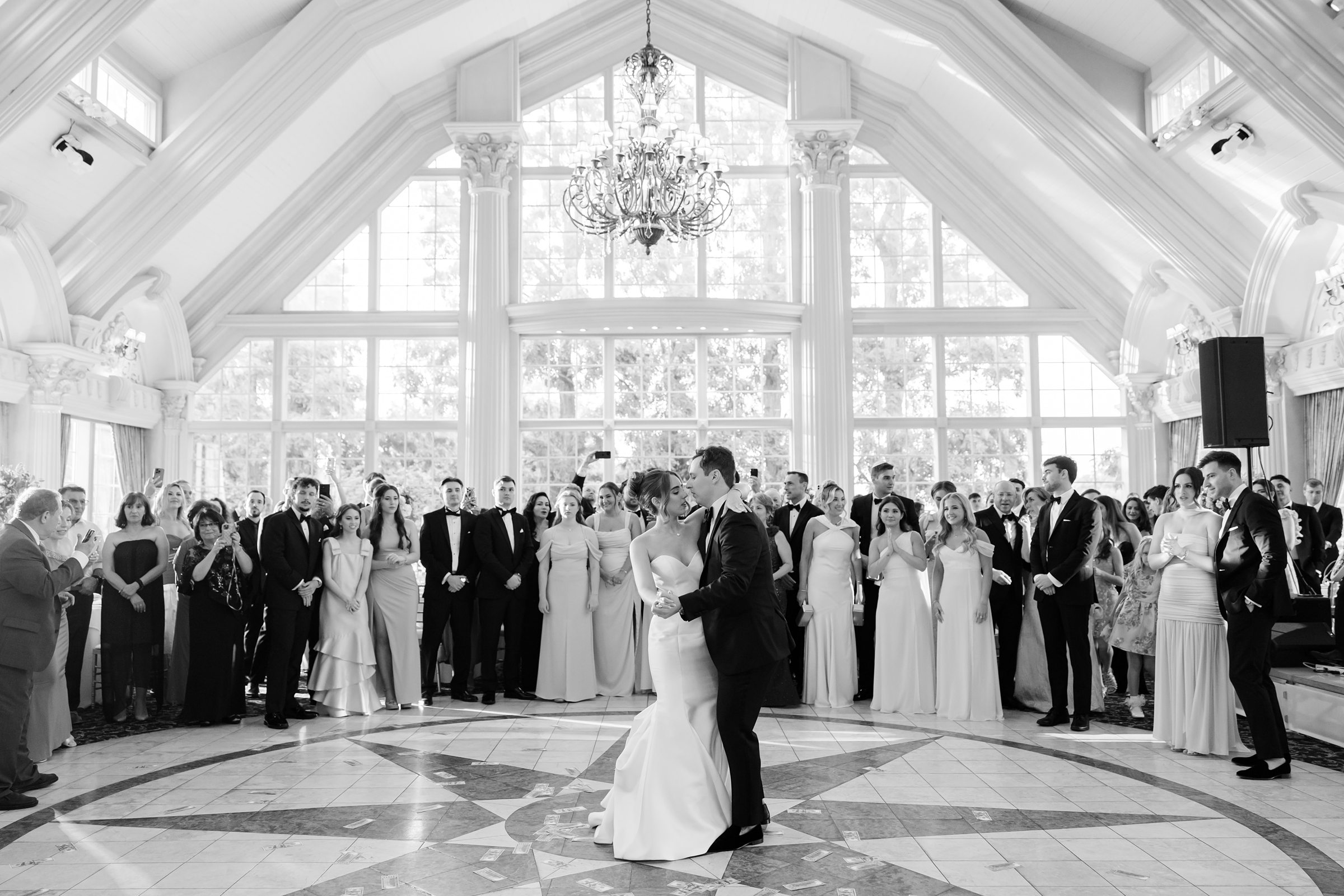Bride and groom dancing in front of the guests, the picture is in black and white color