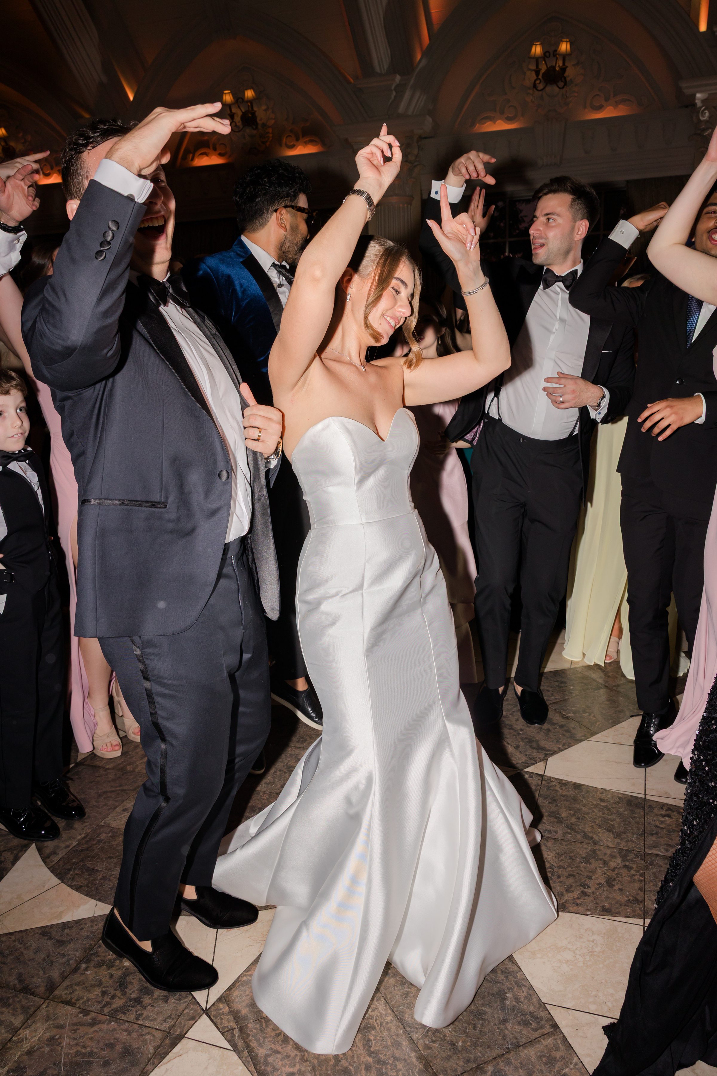 Bride and groom dancing together with the guests.